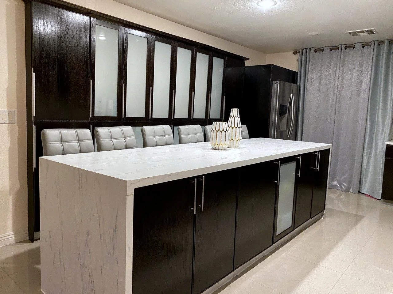 a remodeled kitchen island with smooth marble decor, professionally installed cabinetry, and smooth tile