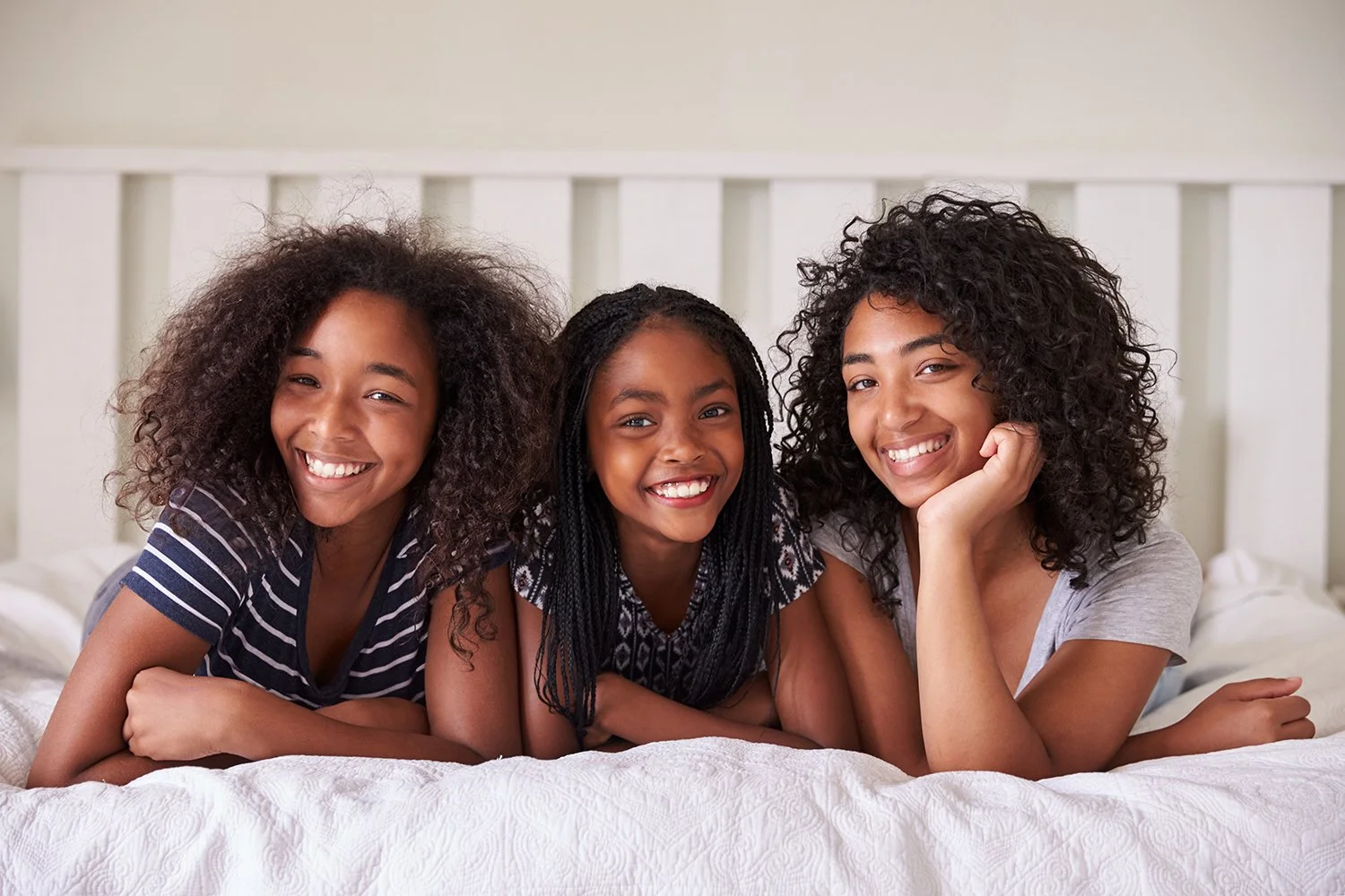 Group of three girls, happy, hanging out at home.