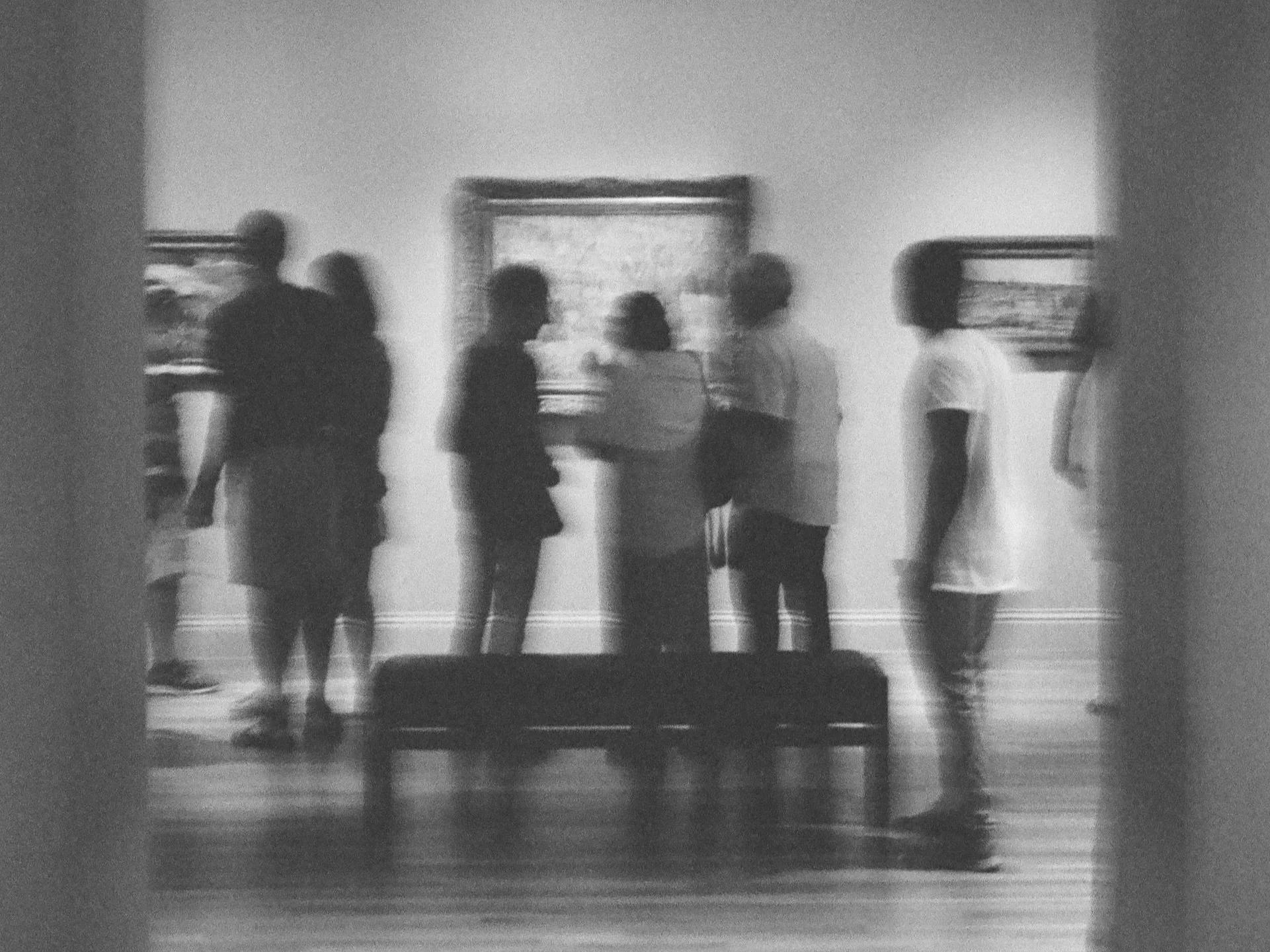 black and white film photograph of visitors viewing a painting at the reynolds gallery art museum in washington dc