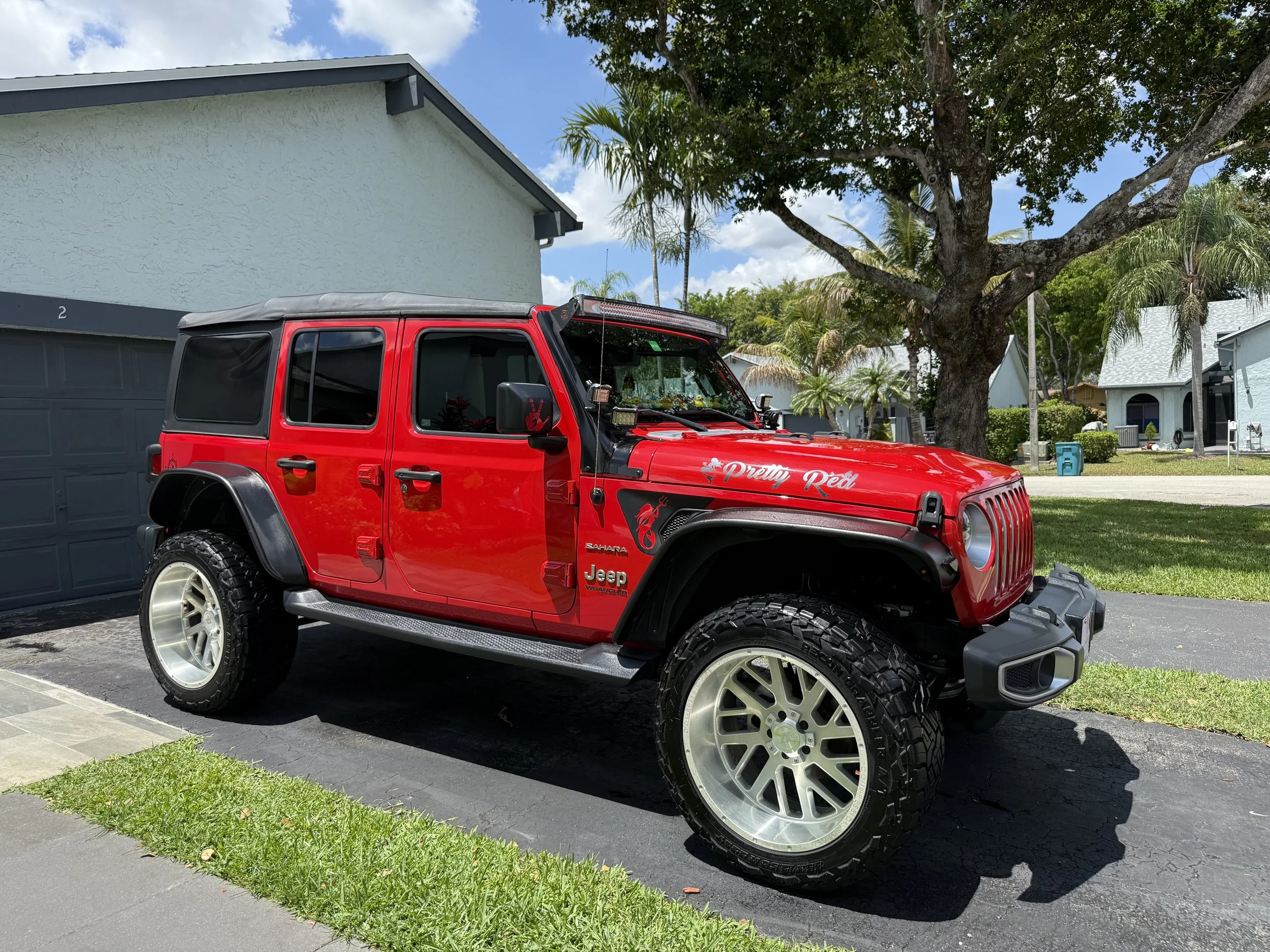 Red Jeep Wrangler parked in driveway, looking brand new from the detailers work.