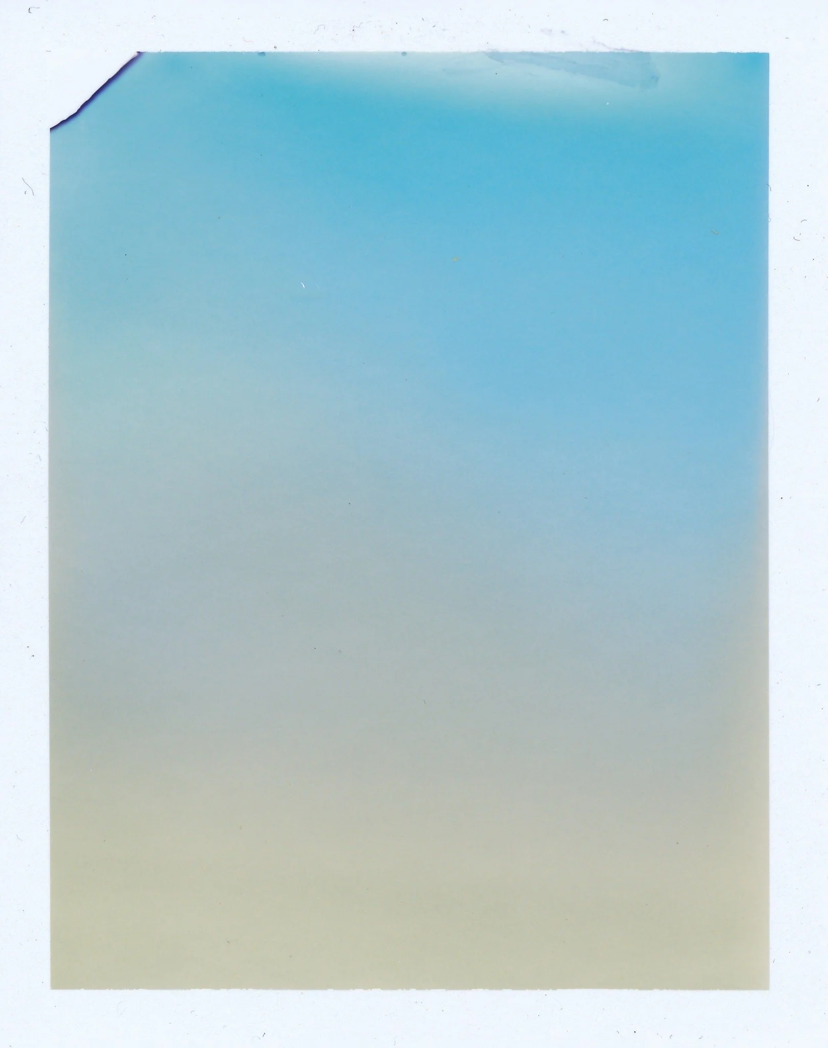 A torn piece of paper with a gradient from light beige at the bottom to blue at the top, heart-shaped torn corner at the top left.