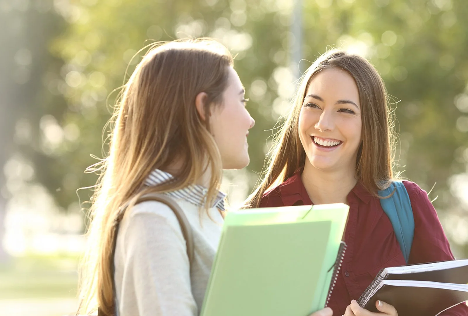 Two students smile and look at one another
