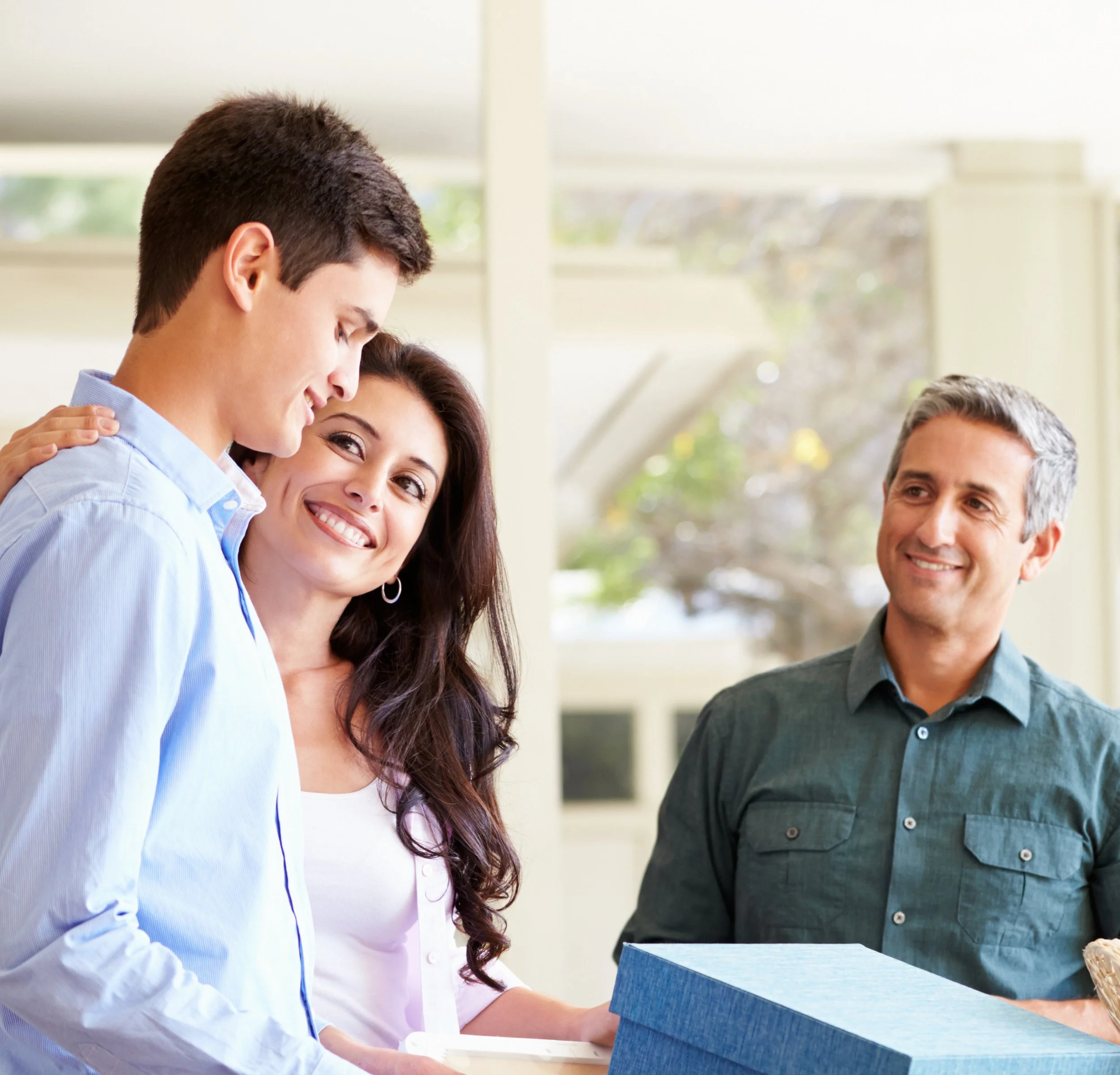 A student is seen packing boxes as his parents smile at him