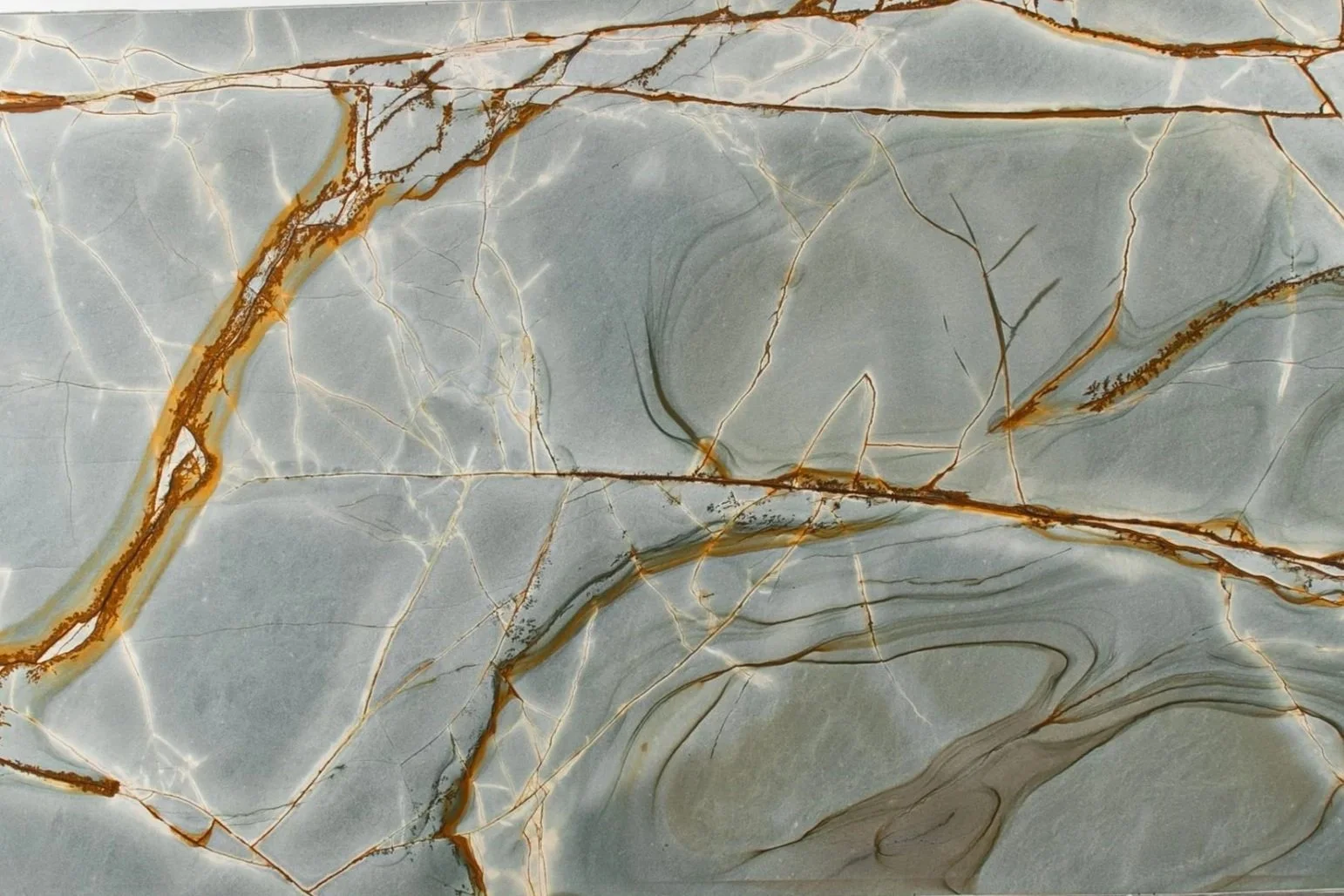 Close-up of a marble surface with light grey and white tones and brown veining patterns.