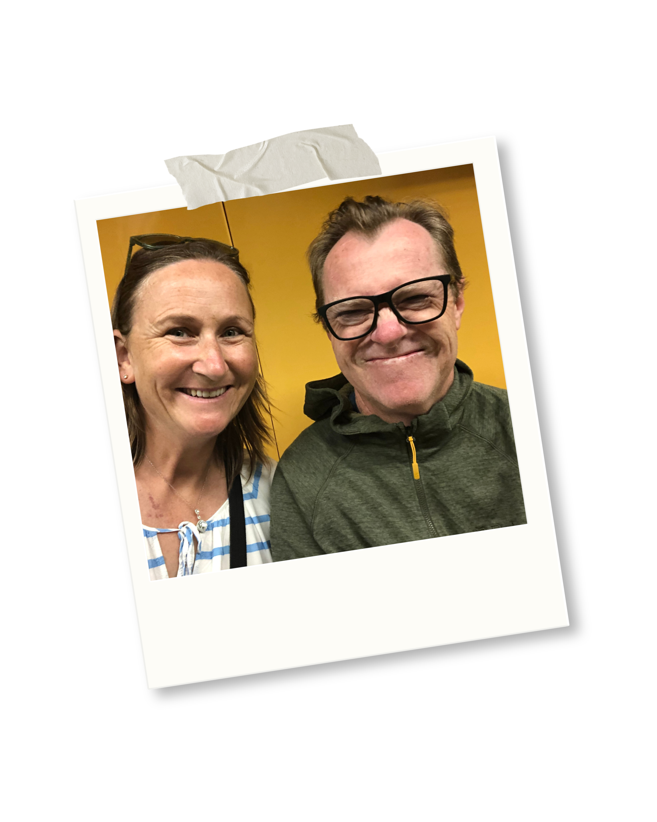 A smiling woman and man taking a selfie together against a yellow background, with the photo appearing as a slightly tilted Polaroid with torn tape at the top.