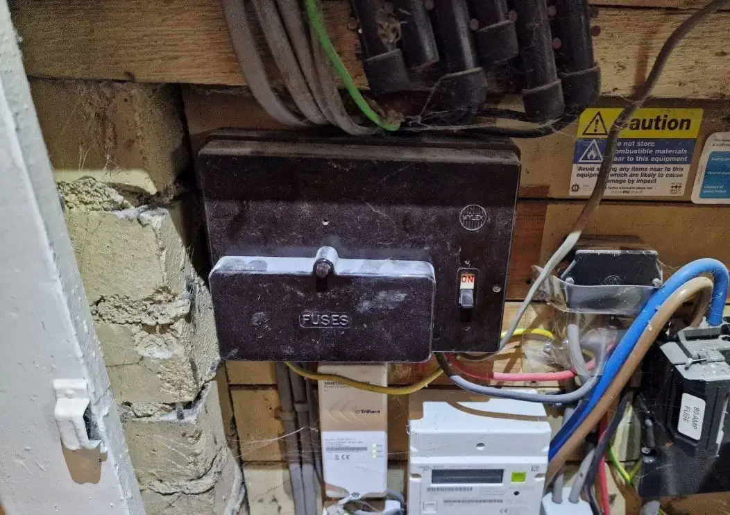 rewireable Wylex fuse box uses color-coded plastic carriers with thin strands of fuse wire