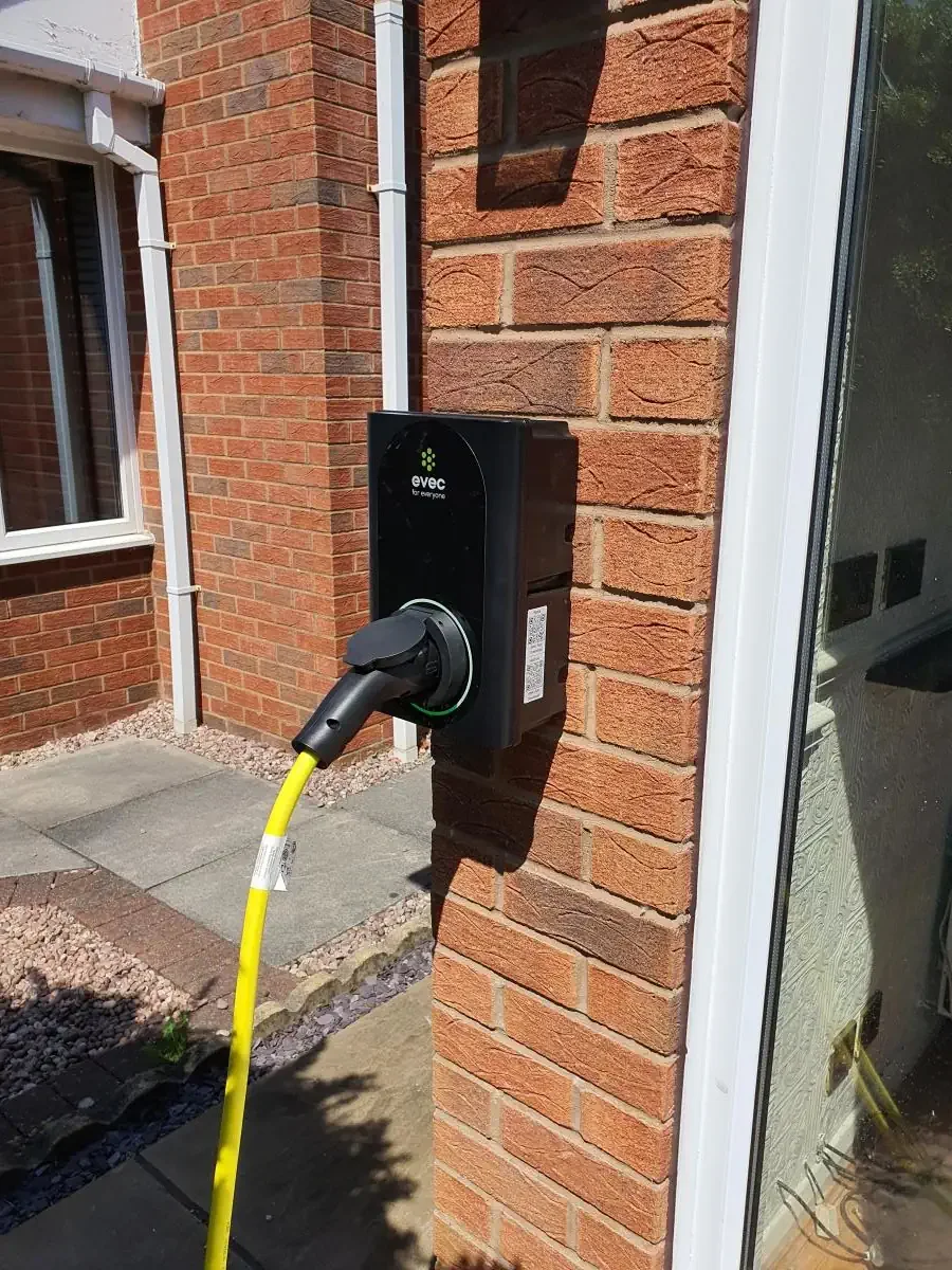 7.5kw ev charger installed at wall. Yelow charging lead connected to charger socket