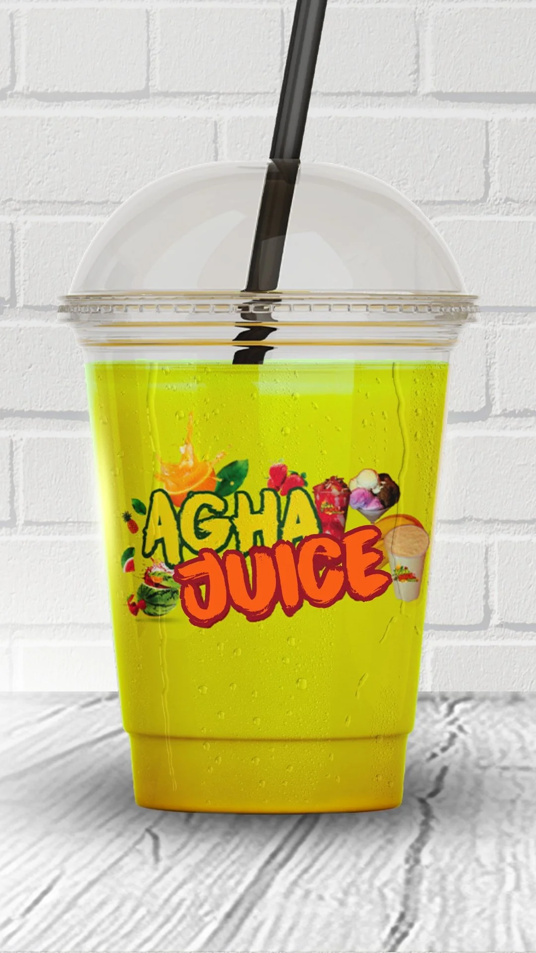Close-up of a yellow plastic cup with a clear lid and black straw, labeled "Acha Juice," placed on a white wooden surface with a white brick wall background.