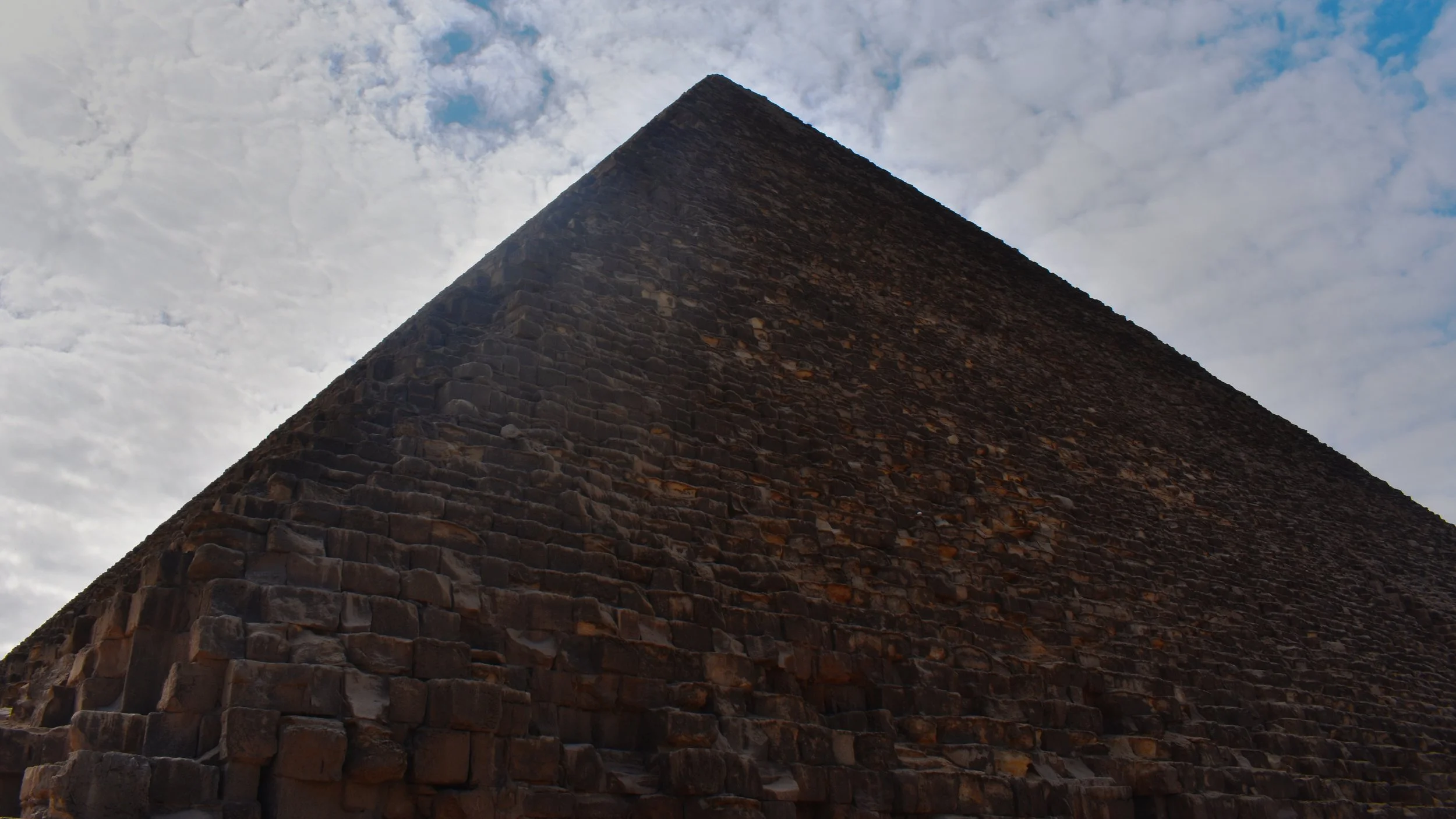 Pyramids set against cloudy sky