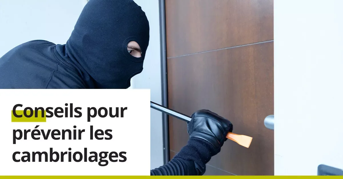 Un cambrioleur masqué en train de forcer une porte d'entrée avec des outils.