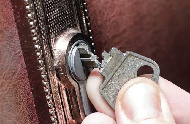 une clé cassé dans une serrure sur une porte en bois.