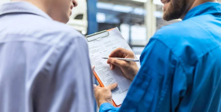 Deux hommes de dos en chemises avec un bloc note à la main pour effectuer un devis