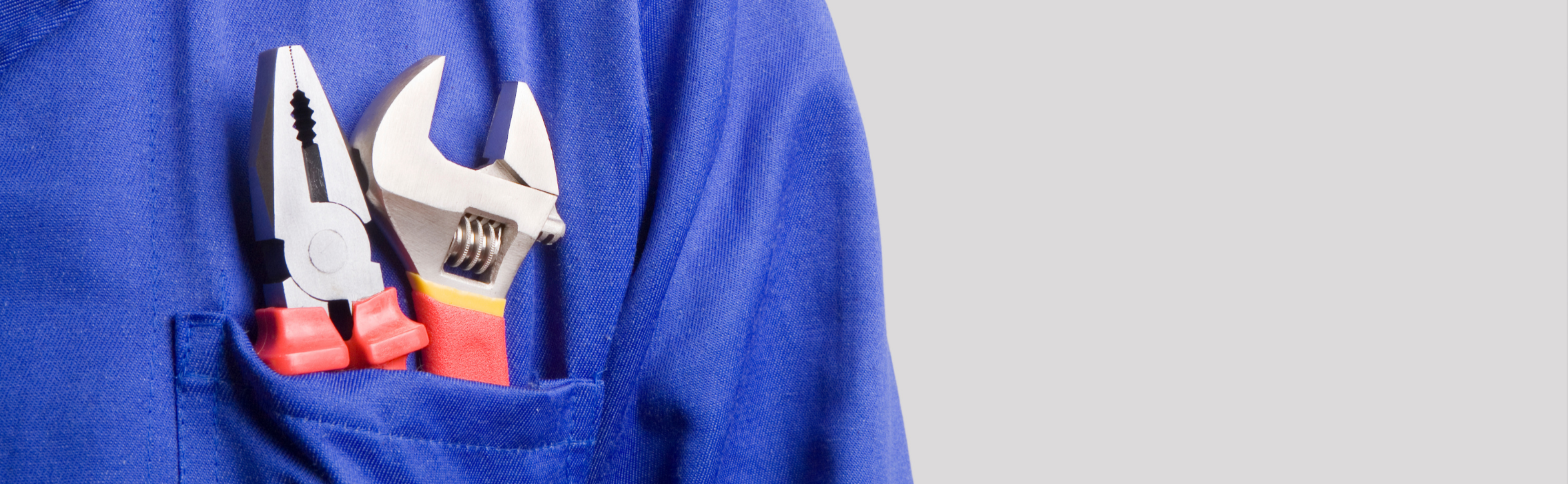 Deux paires de pince dans la poche d'une veste bleue.