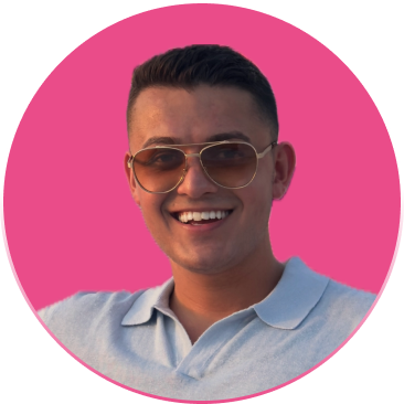 A young man smiling with sunglasses, wearing a light blue polo shirt, against a pink circular background.