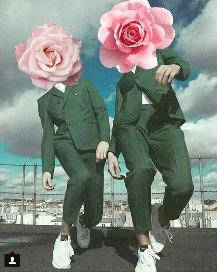 Two people with rose flowers as their faces, wearing green suits, standing outdoors against a cloudy sky background.
