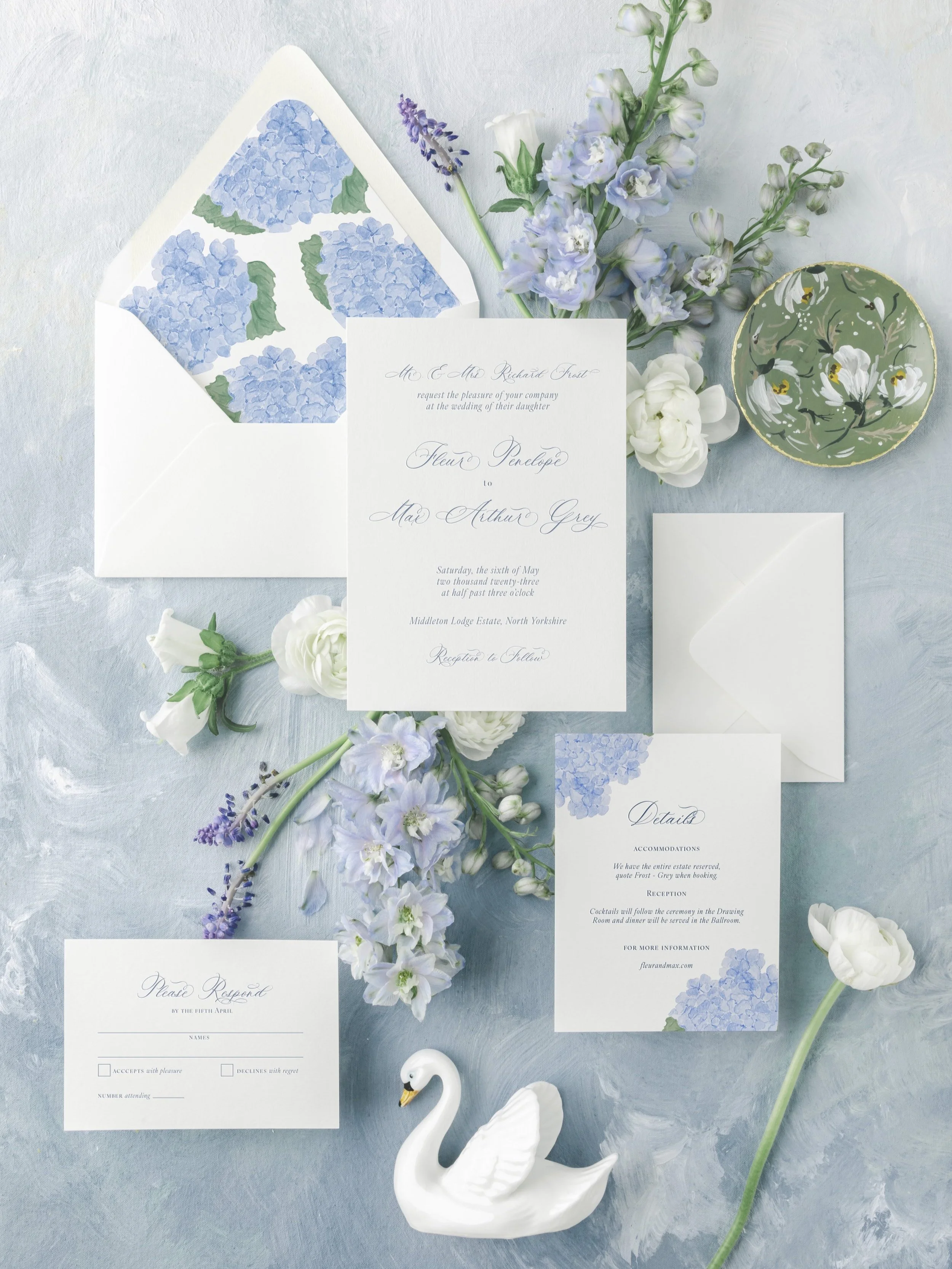 The Fleur Collection wedding suite with large-scale pale blue watercolor hydrangeas and delicate script typography. A timeless, botanical-inspired design perfect for a romantic garden wedding.