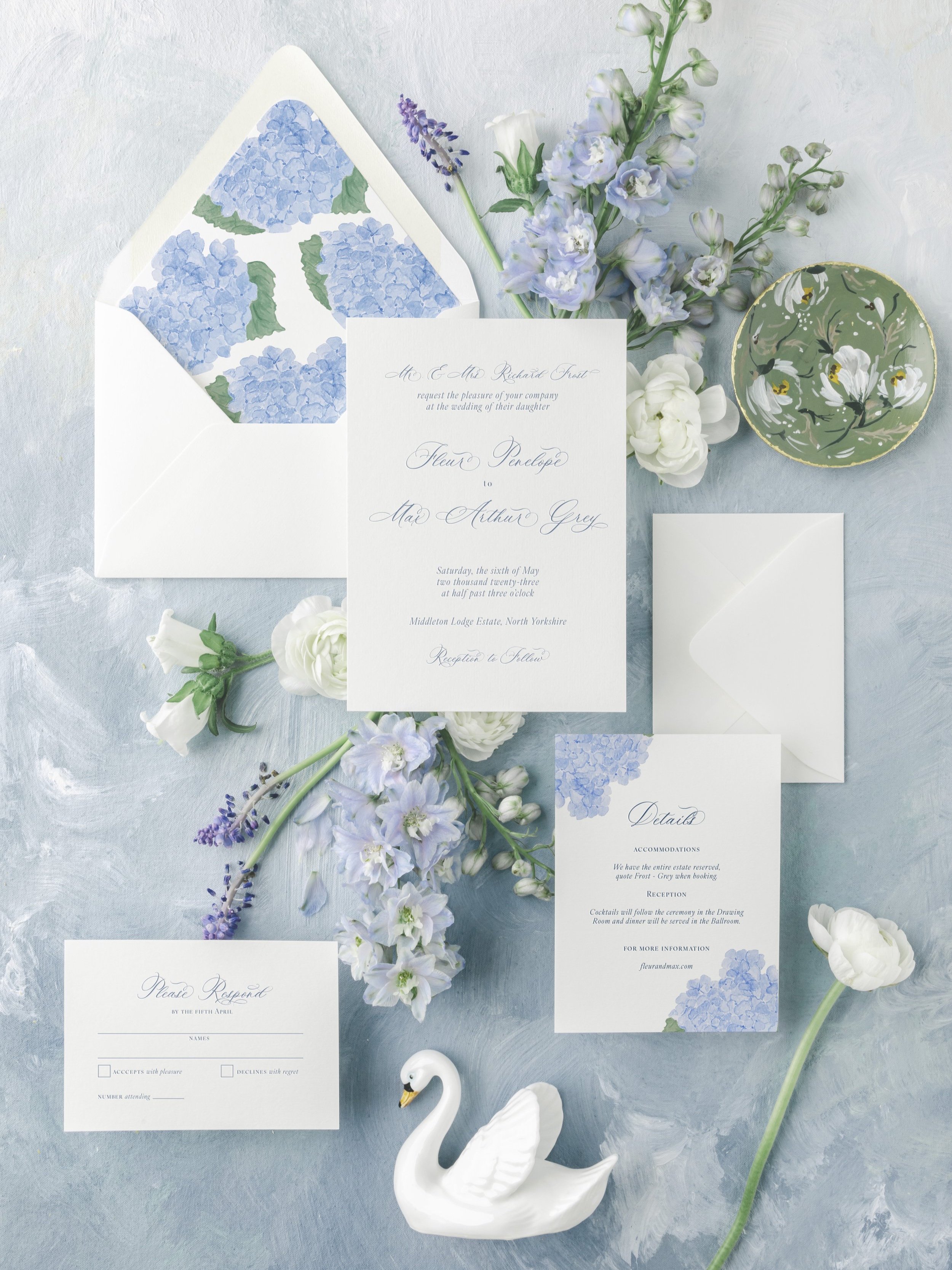 The Fleur Collection wedding suite with soft blue watercolor hydrangeas, classic script typography, and a romantic botanical design.