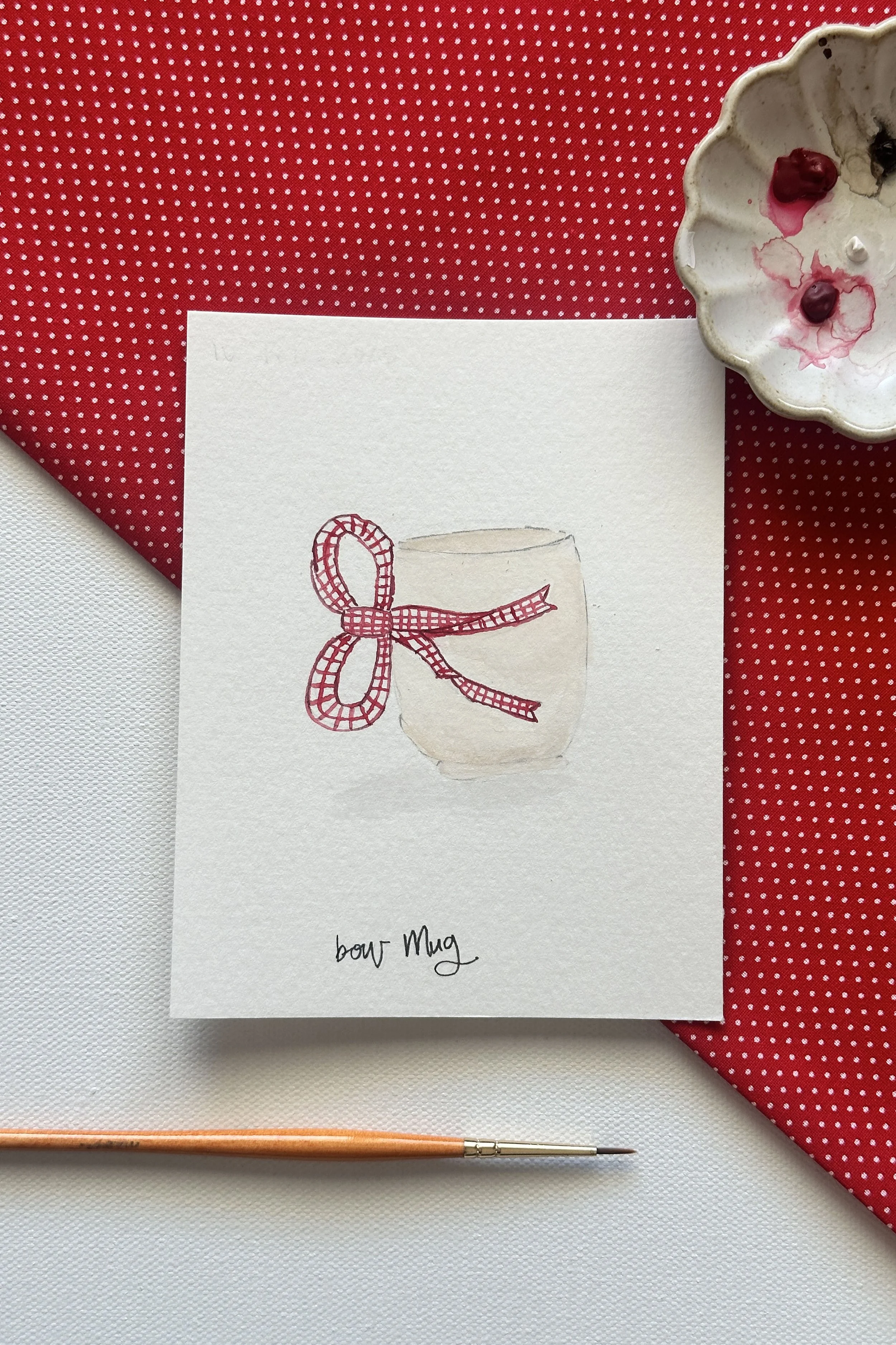 A watercolor mug with a red bow, painted for the Valentine’s Day theme in February.