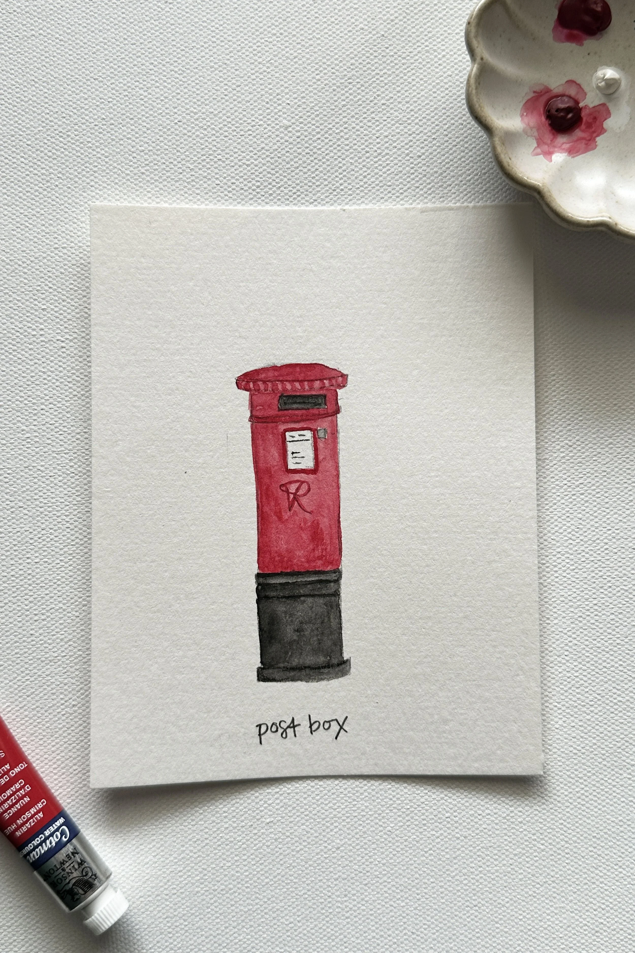 A watercolor painting of a classic red British postbox.