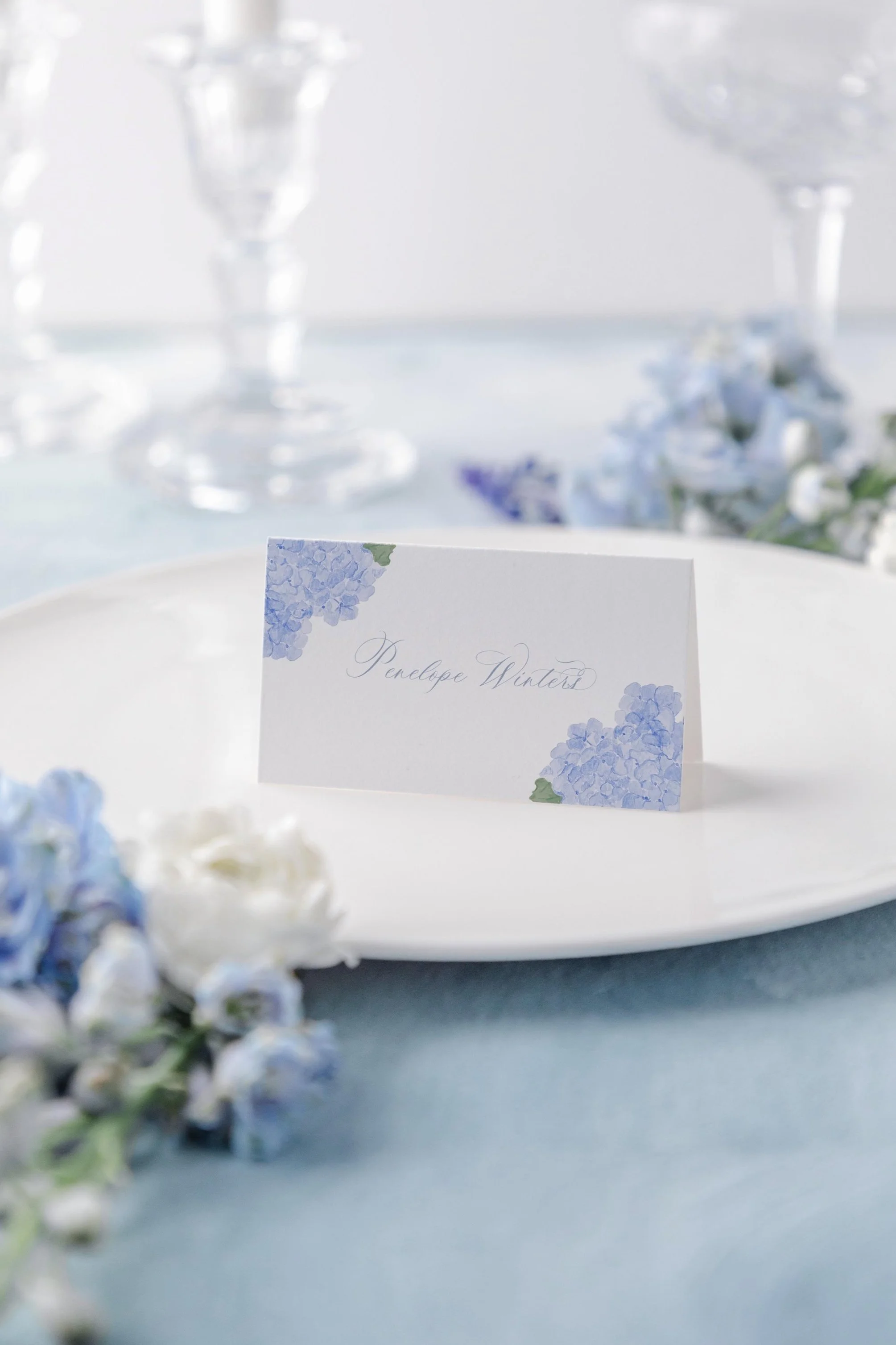Fleur place cards with pale blue watercolor florals, designed for elegant wedding tablescapes.