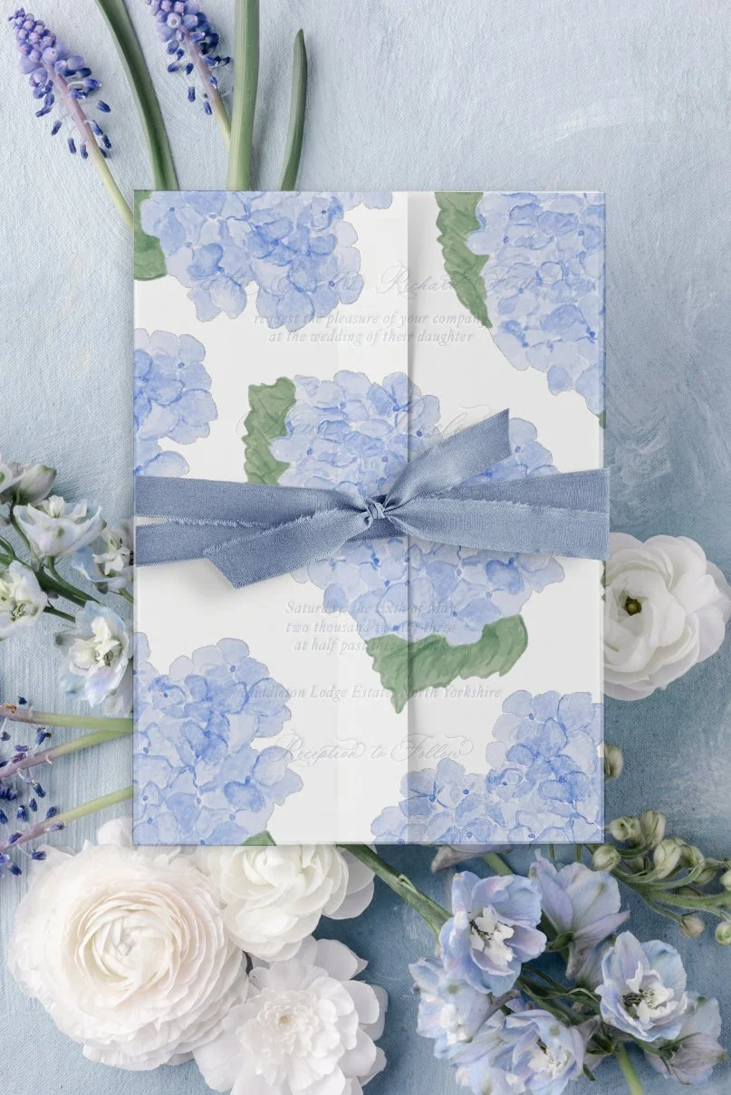 Fleur wedding invitation layered with a vellum wrap and tied with silk ribbon for a romantic finish.