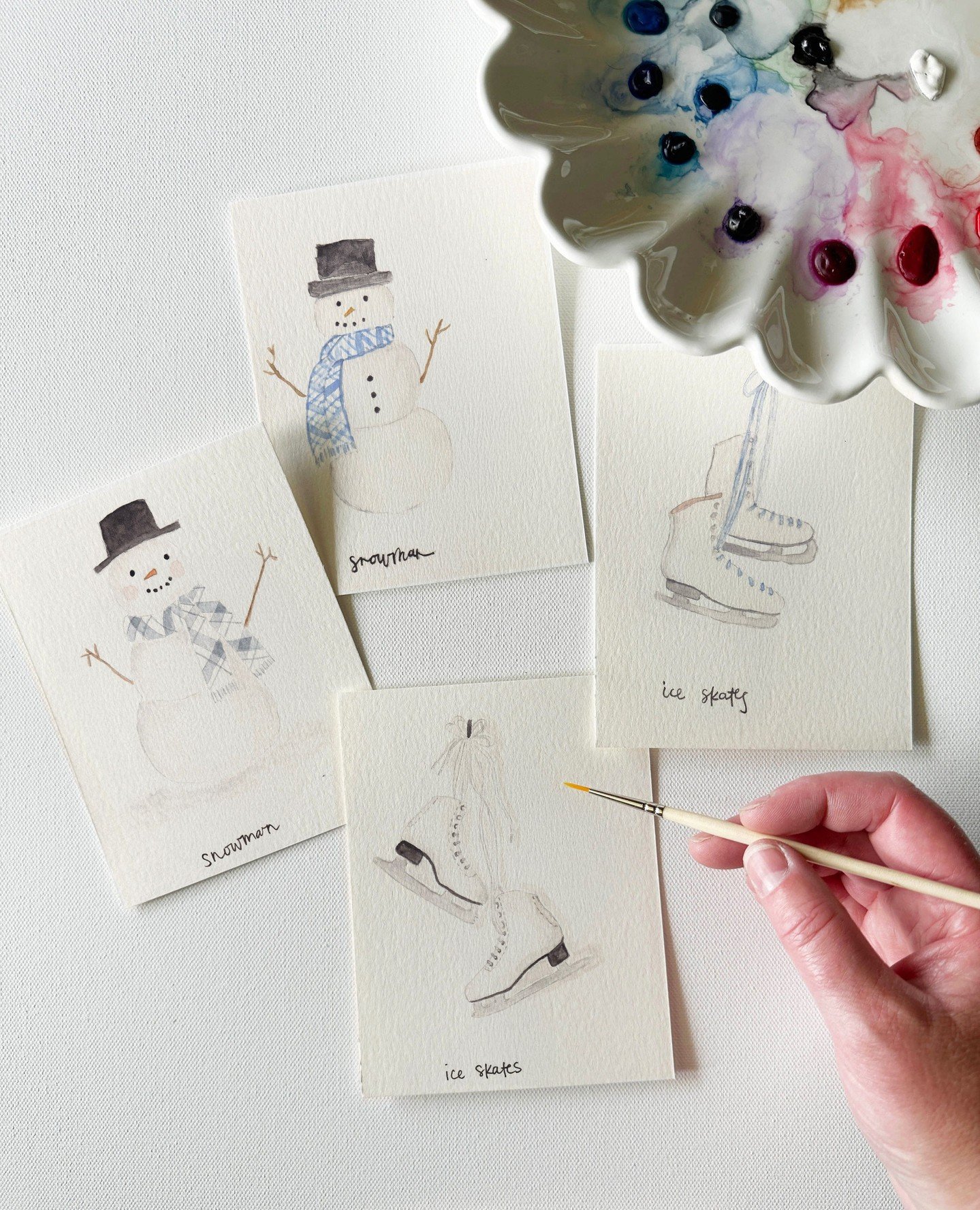 A year ago, I painted these snowmen and ice skates. I remember sitting at this same table, mixing the same blues, trying to get the scarf to look right.⁠
⁠
At the time, I was proud of them. And I still am. But I painted them again &mdash; just to see