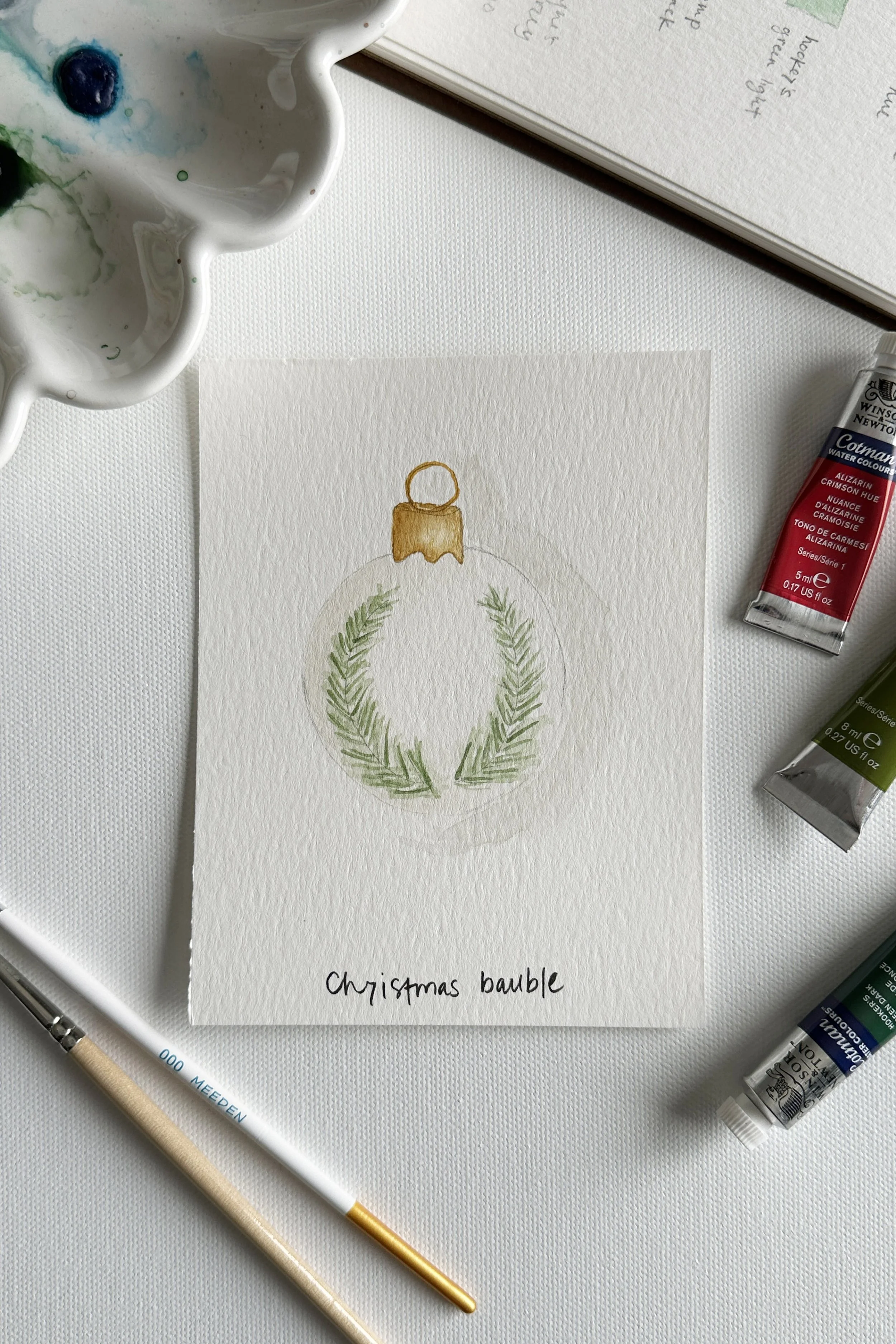 A watercolor Christmas ornament painted for the December holiday theme.
