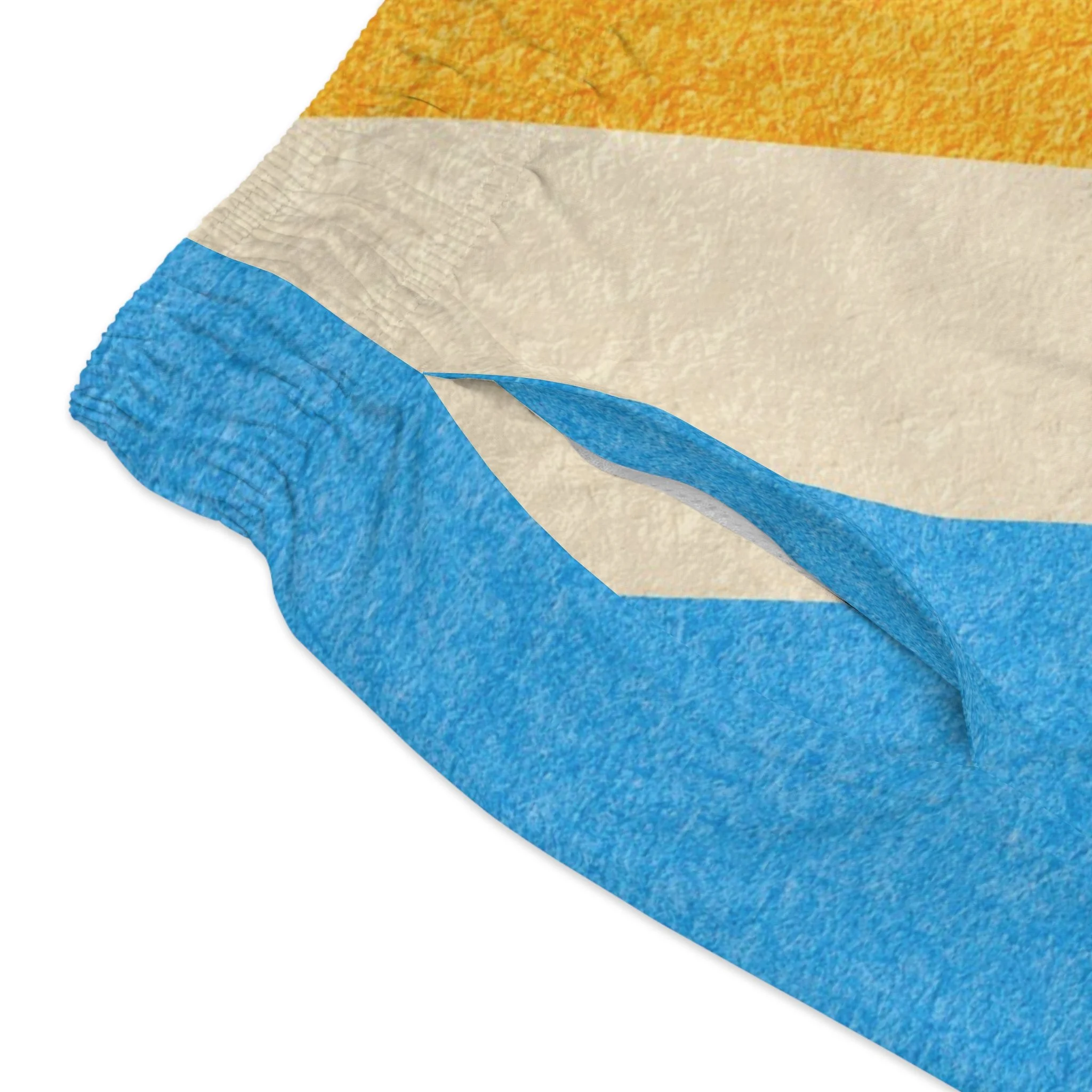 Close up of diagonal colorblock panel design on Hunt and Harbor men's retro swim trunks in sky blue amber and cream