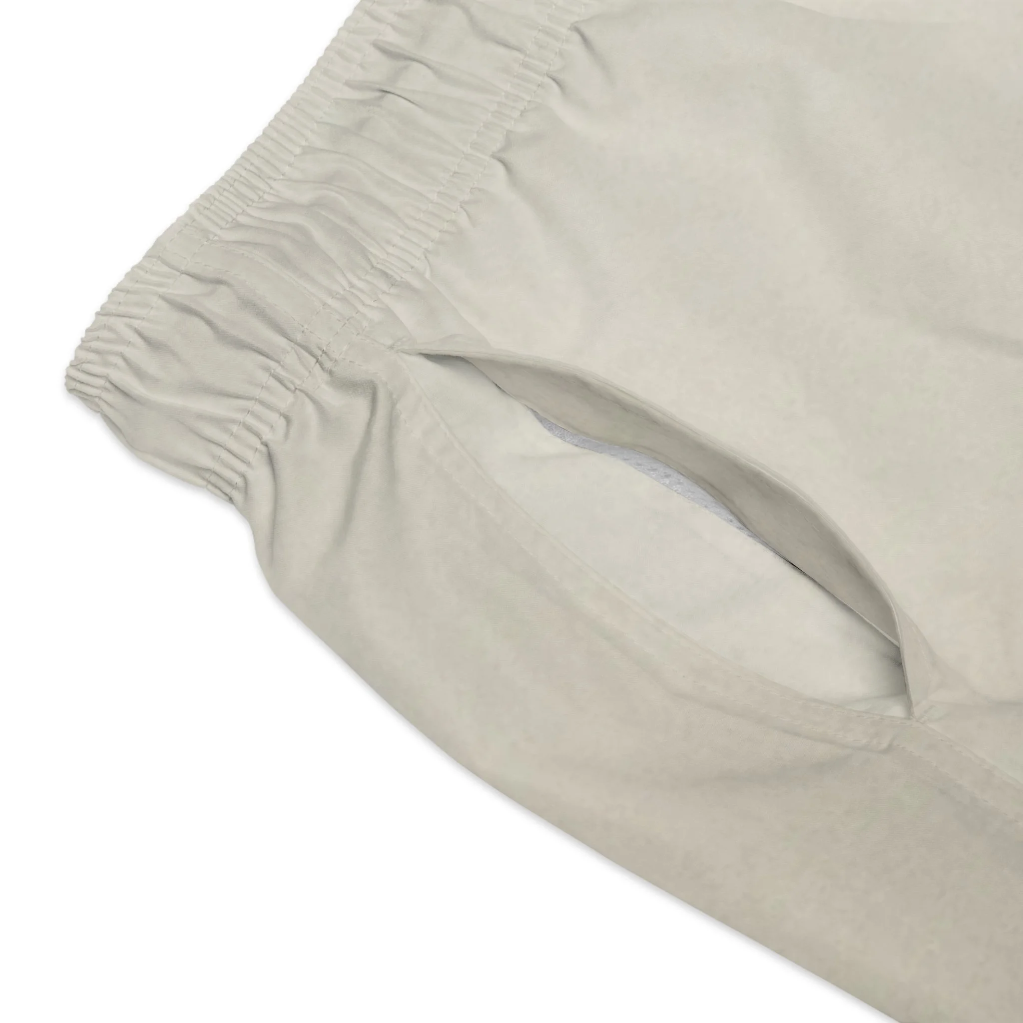 Close up of neutral ombré gradient fade and Hunt and Harbor gold brand mark on men's minimalist swim trunks