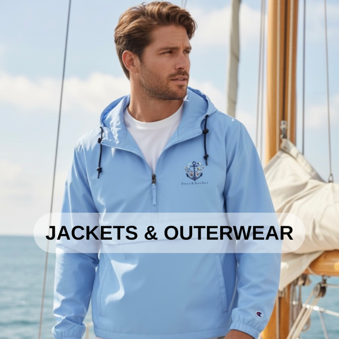 A man wearing a light blue jacket with a nautical anchor logo, standing on a boat with the ocean in the background.
