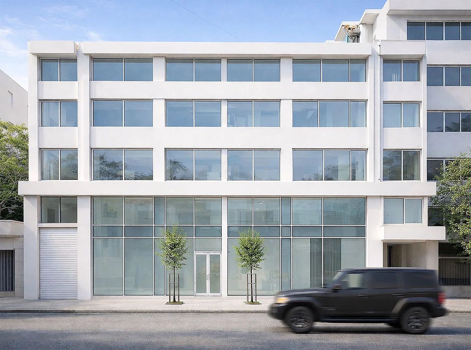 A four floor white apartment and a black car in front of it
