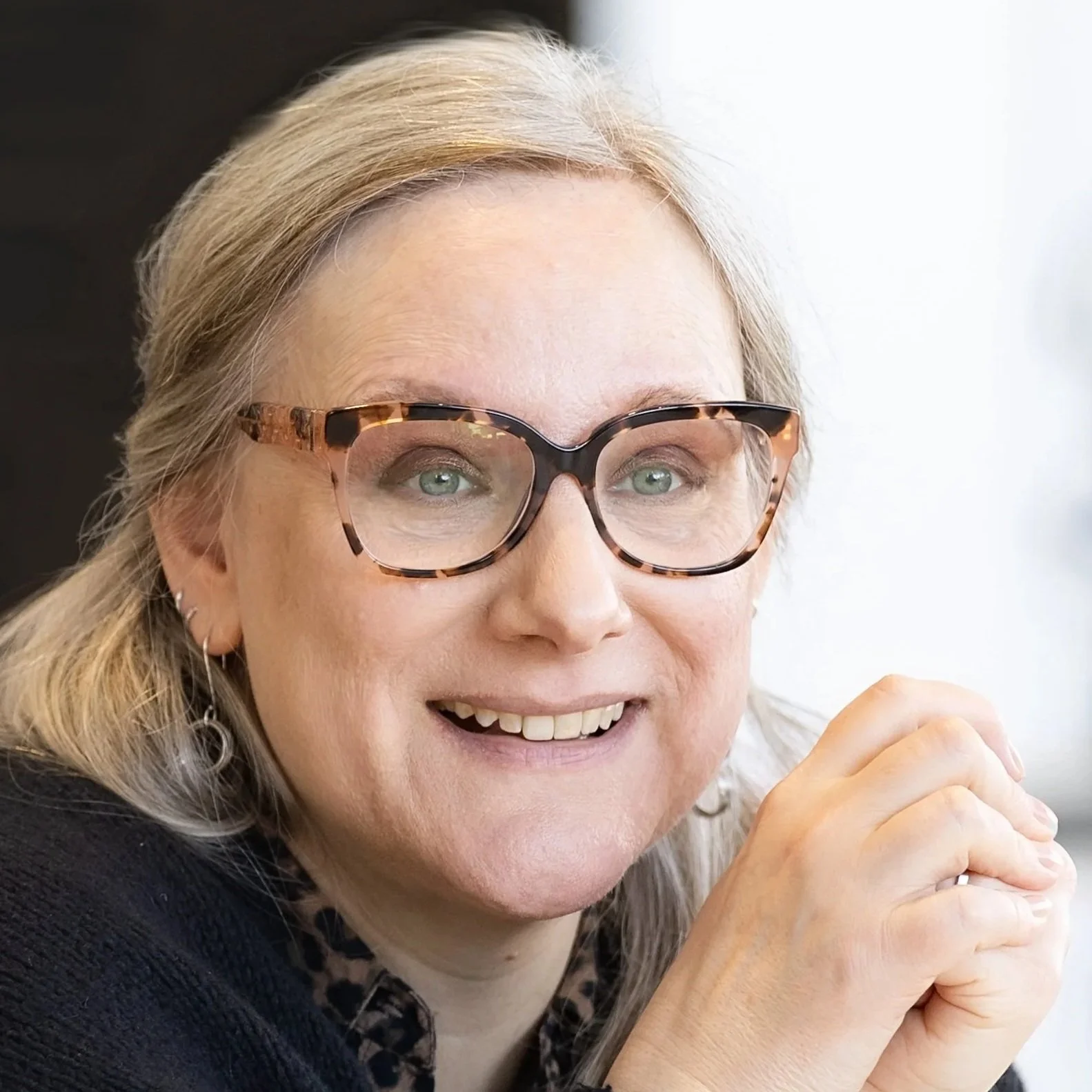 A photo of Jesmond Allen. A smiling white woman with glasses and long grey hair