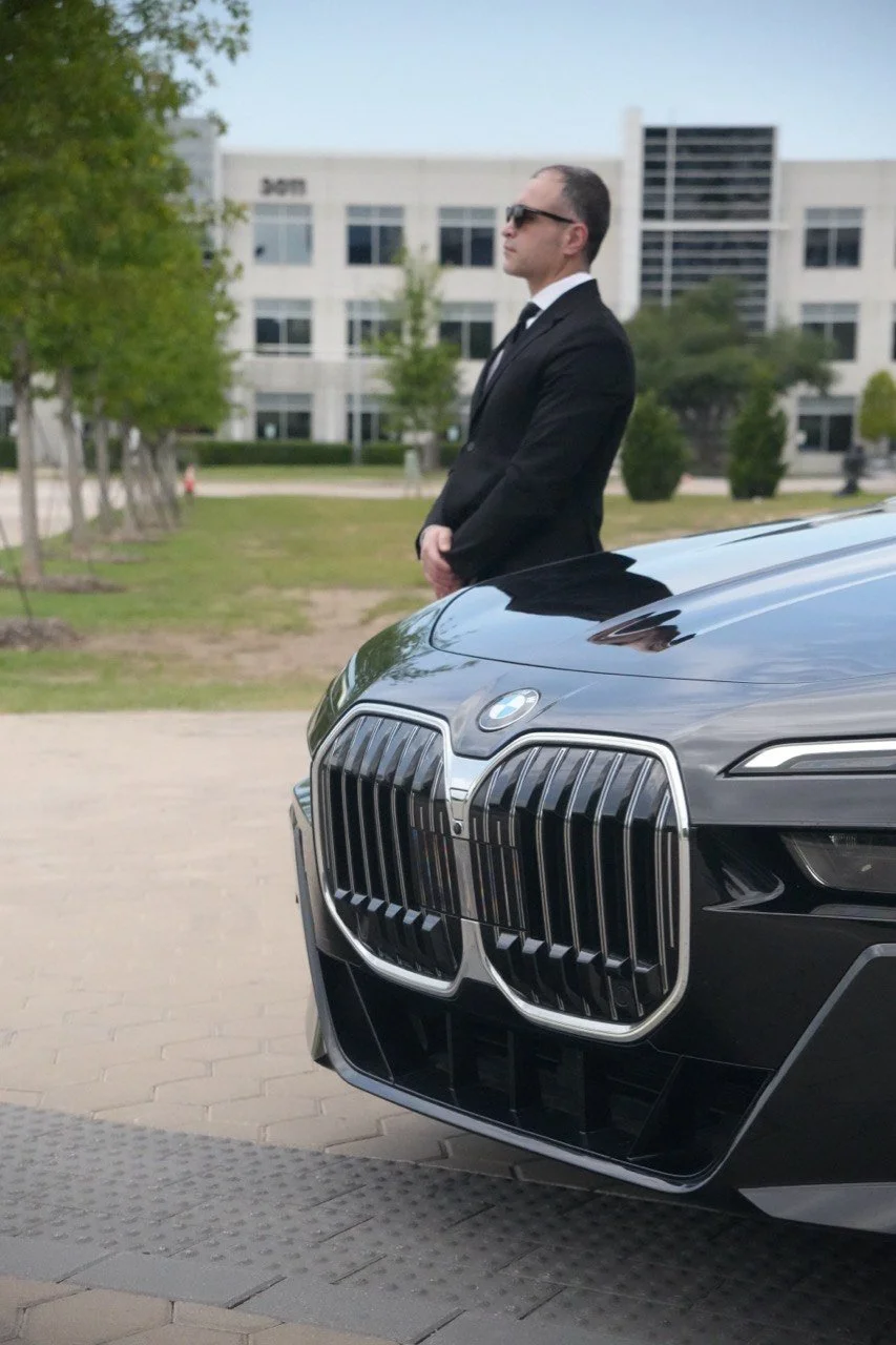 Professional chauffeur beside a BMW 7 Series providing executive chauffeur service in Dallas for airport transfers and corporate trave