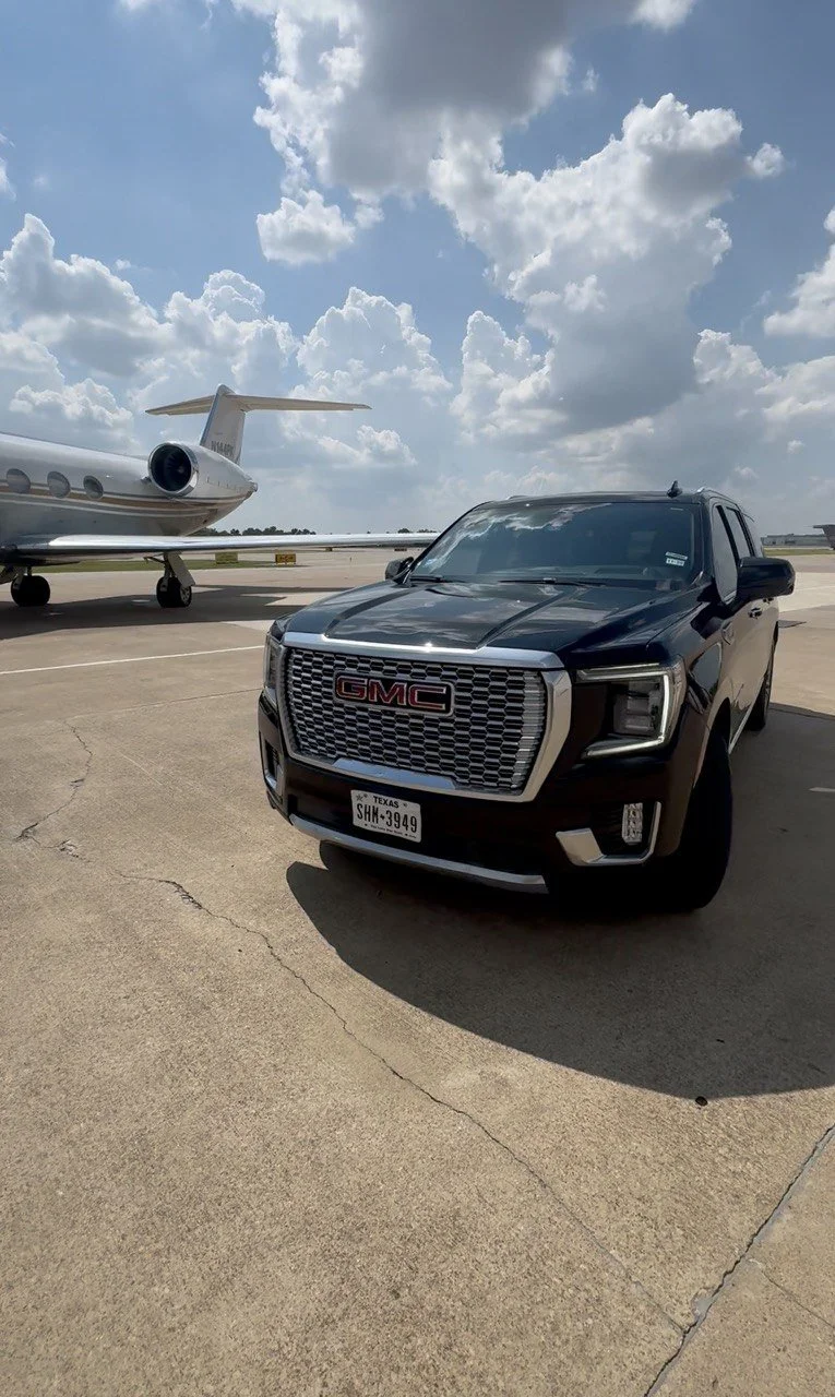 GMC Yukon Denali executive SUV at a private aviation terminal for VIP chauffeur service in Dallas.