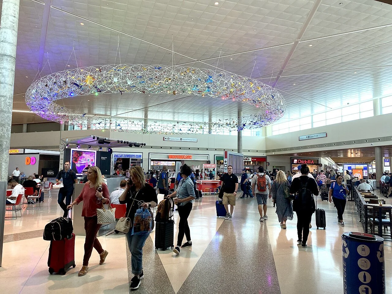 Travelers inside DFW Airport terminal, representing executive airport chauffeur service and luxury transportation in Dallas.