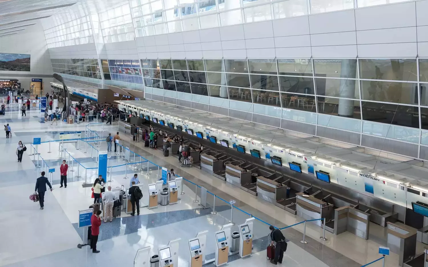 DFW Airport terminal with travelers checking in for flights, representing MP Limousine executive airport chauffeur service in Dallas.