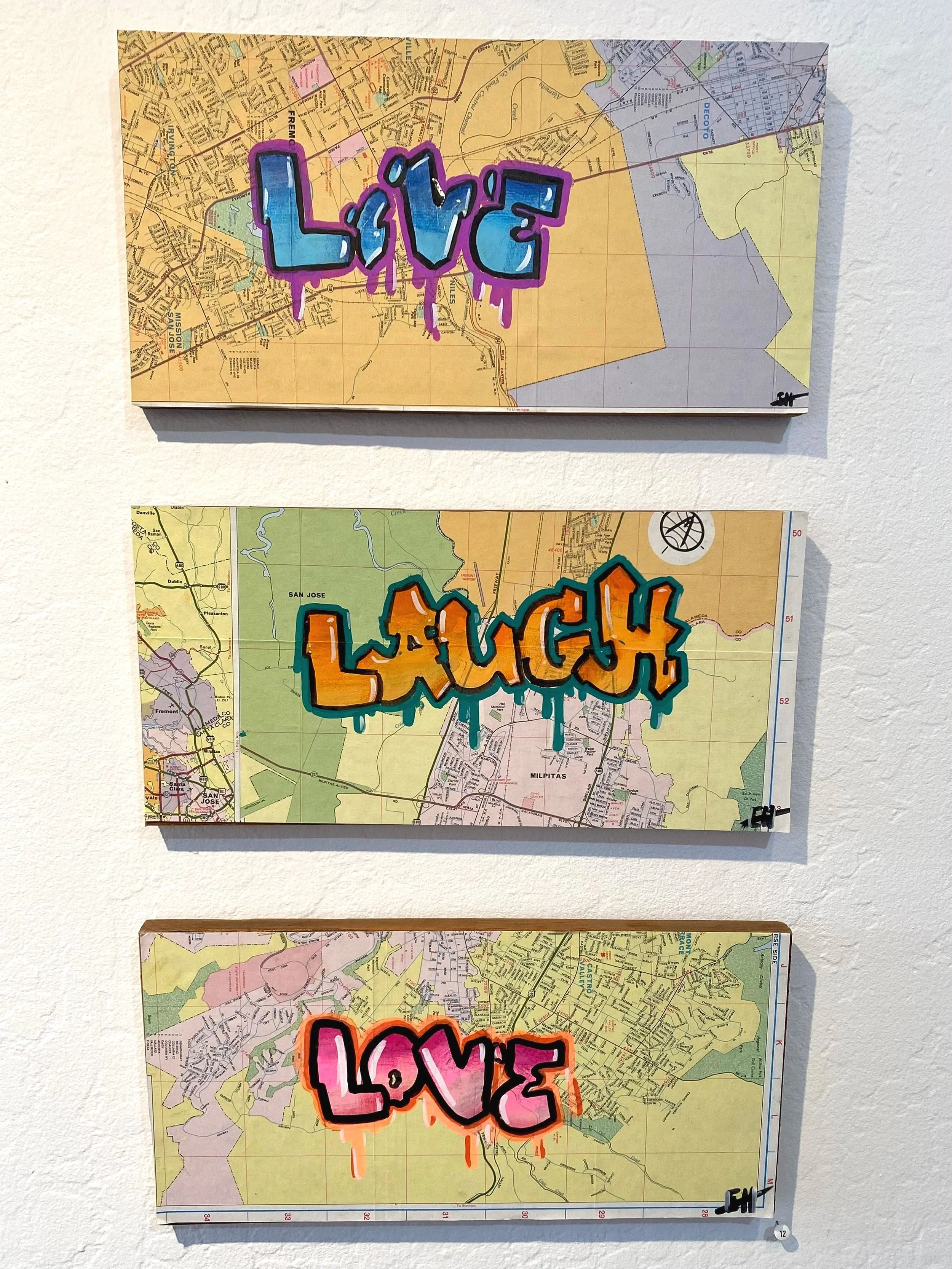 Three maps of different areas with graffiti-style words: "Love" on the top map with a purple and blue color scheme, "Laugh" on the middle map with an orange and teal color scheme, and "Love" on the bottom map with a pink and orange color scheme.