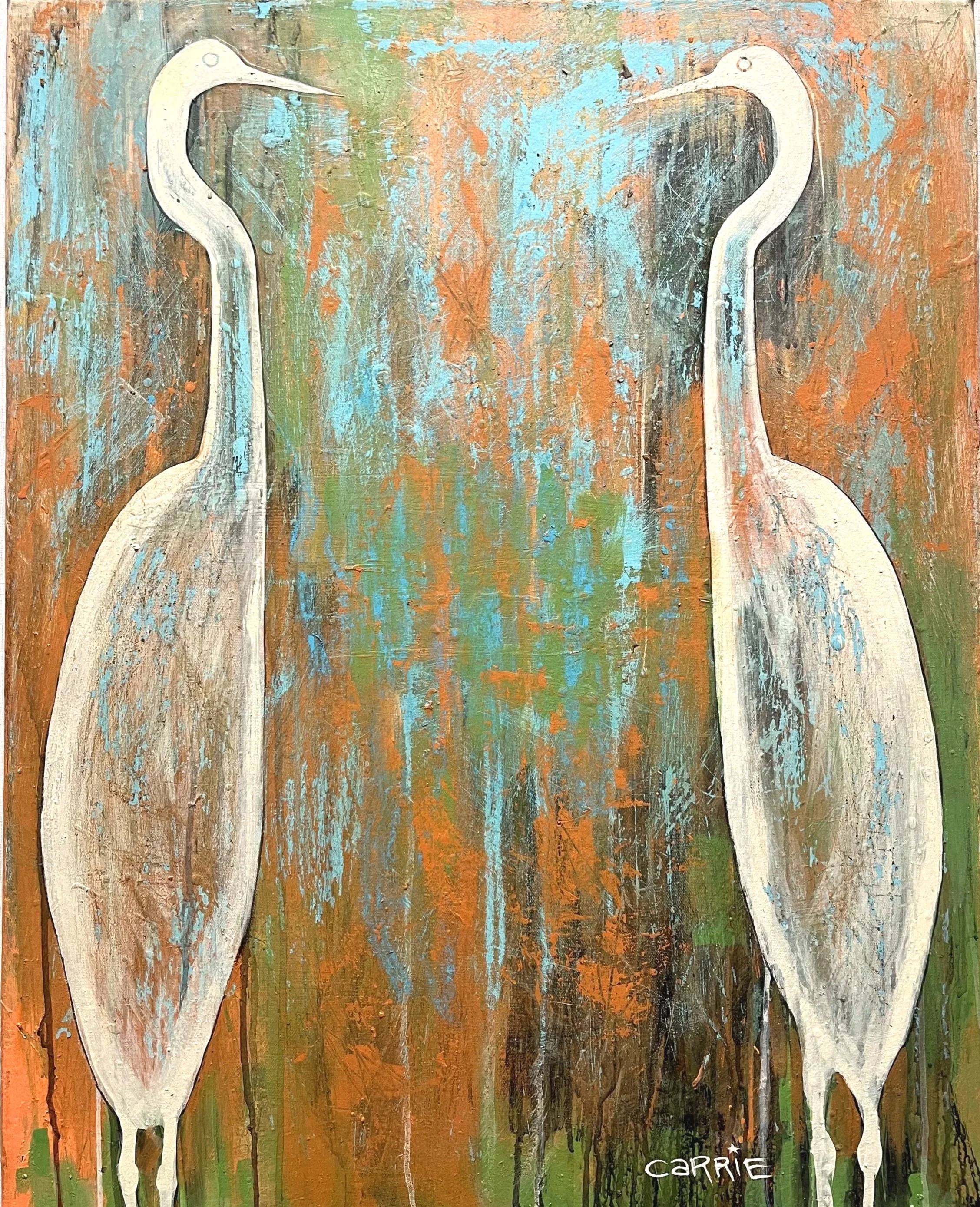 Abstract painting featuring two white herons against a multicolored background of blue, orange, brown, and green hues. The herons are stylized with elongated necks and legs. The artist's signature, 'CARRIE,' is visible in the bottom right corner.