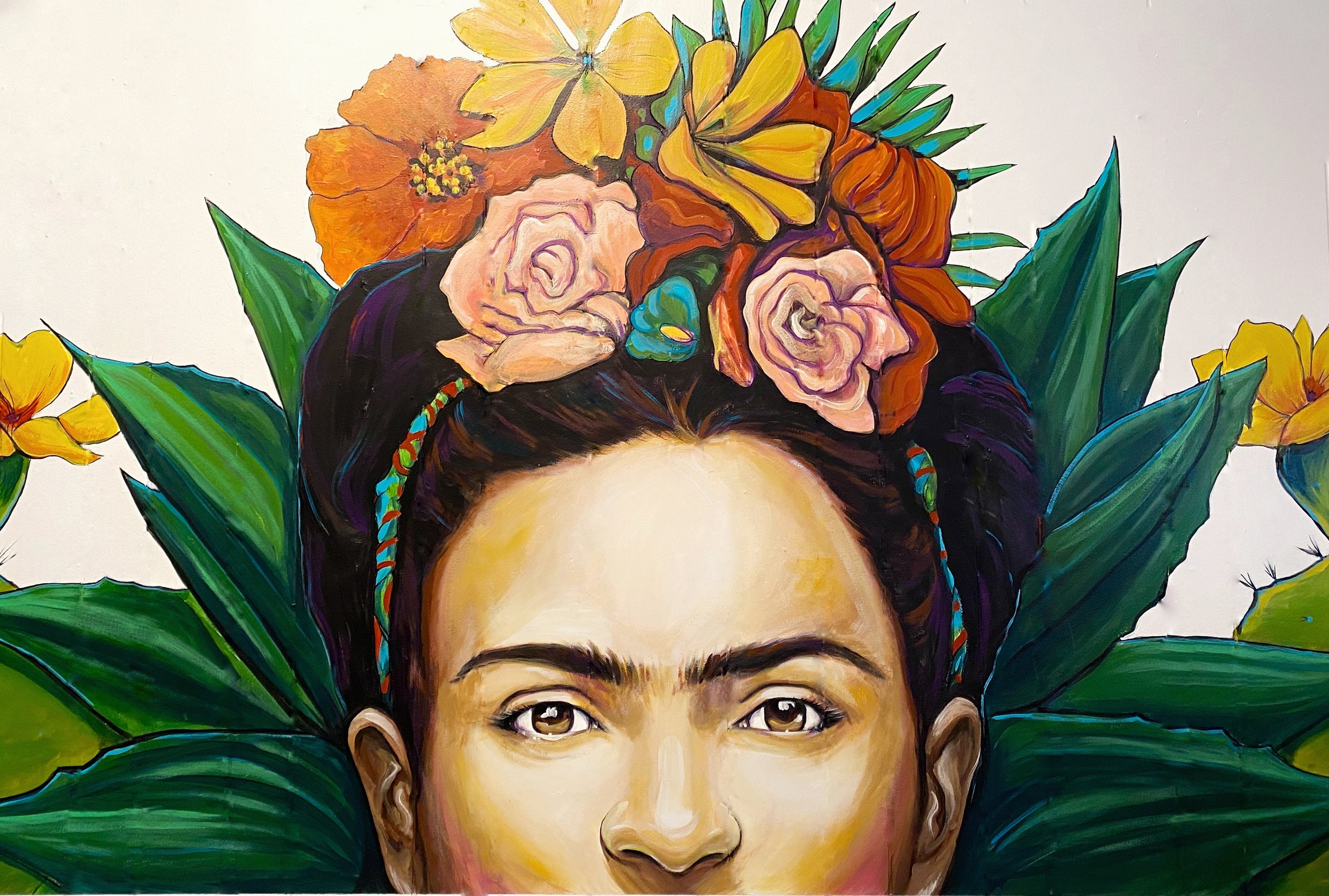 Colorful painting of a woman's face with dark hair decorated with flowers and tropical leaves, including roses and hibiscus, in the background.