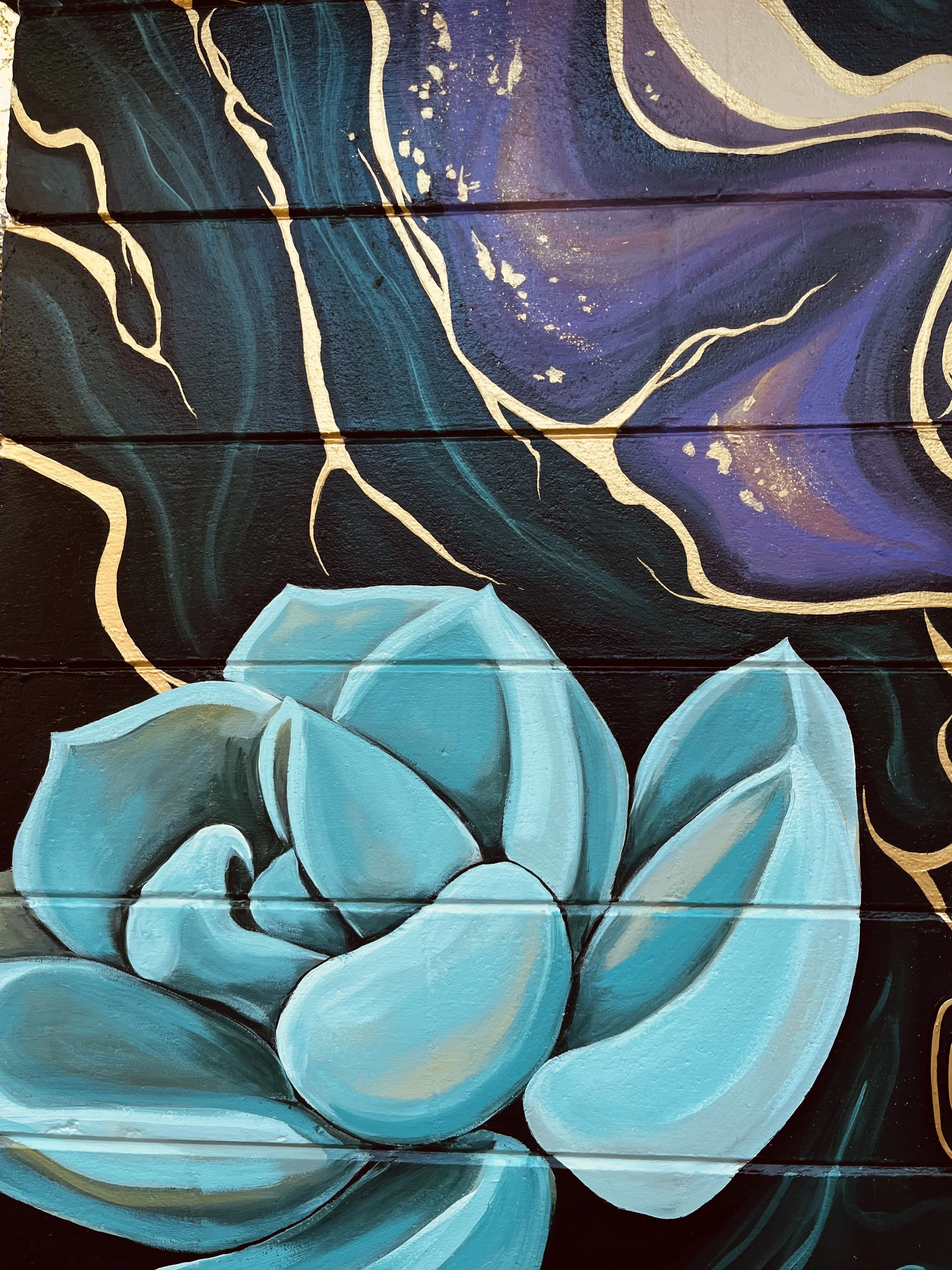 A painted mural of a succulent plant in shades of blue and teal, with a dark, marbled background featuring gold accents and swirling patterns.