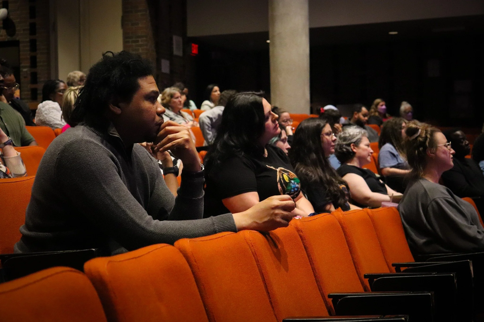 Audience seated in an auditorium listening attentively during a presentation or event.