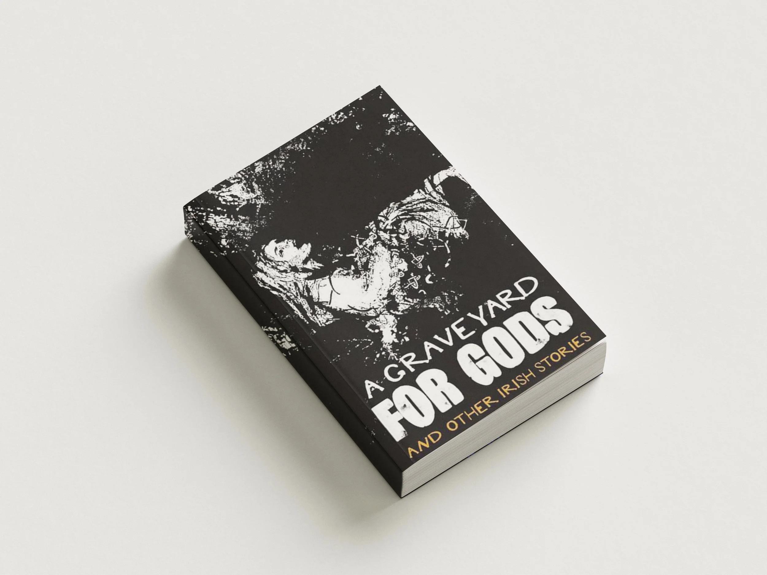 Mock-up image of a paperback book, depicting a black and white illustration of a wailing woman with Celtic inspired designs, bearing the title “A Graveyard For Gods and other Irish stories” on a white background