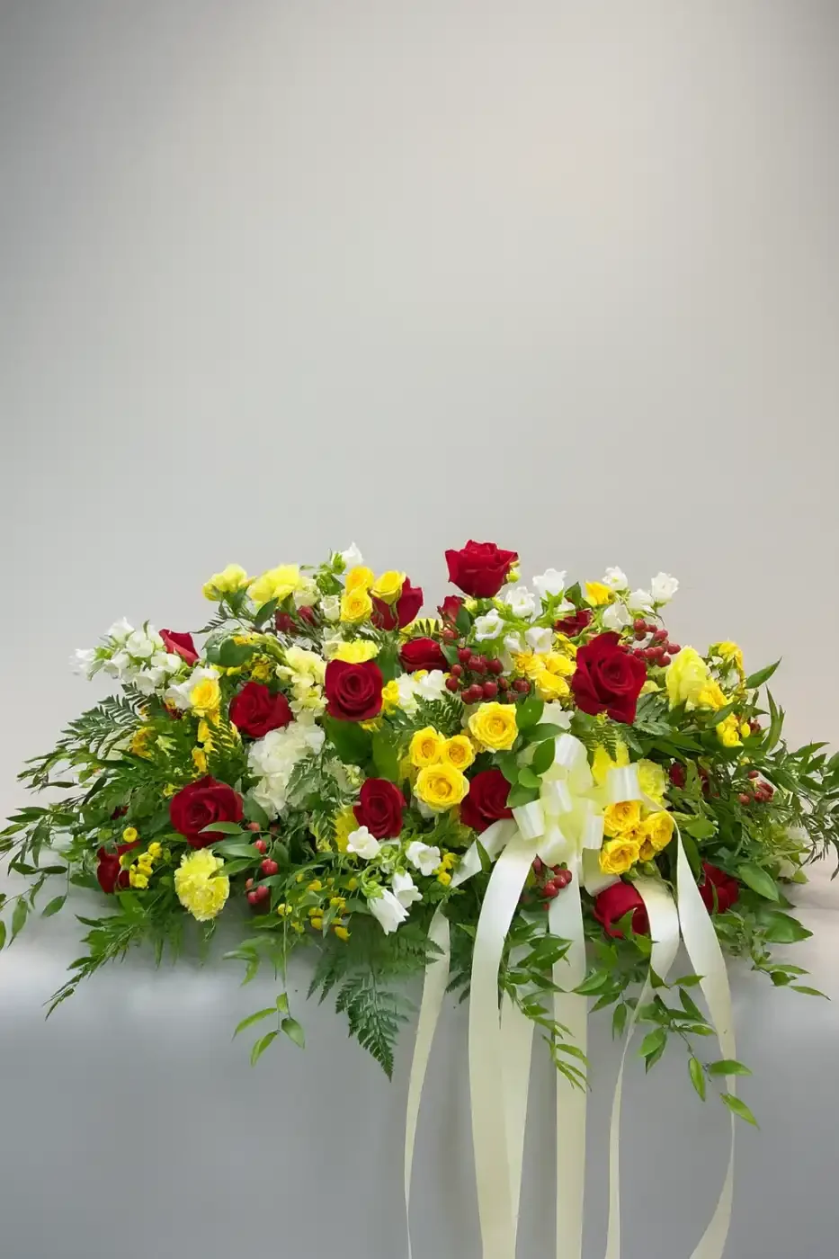 bright-red-yellow-rose-casket-spray-floral-stories.webp