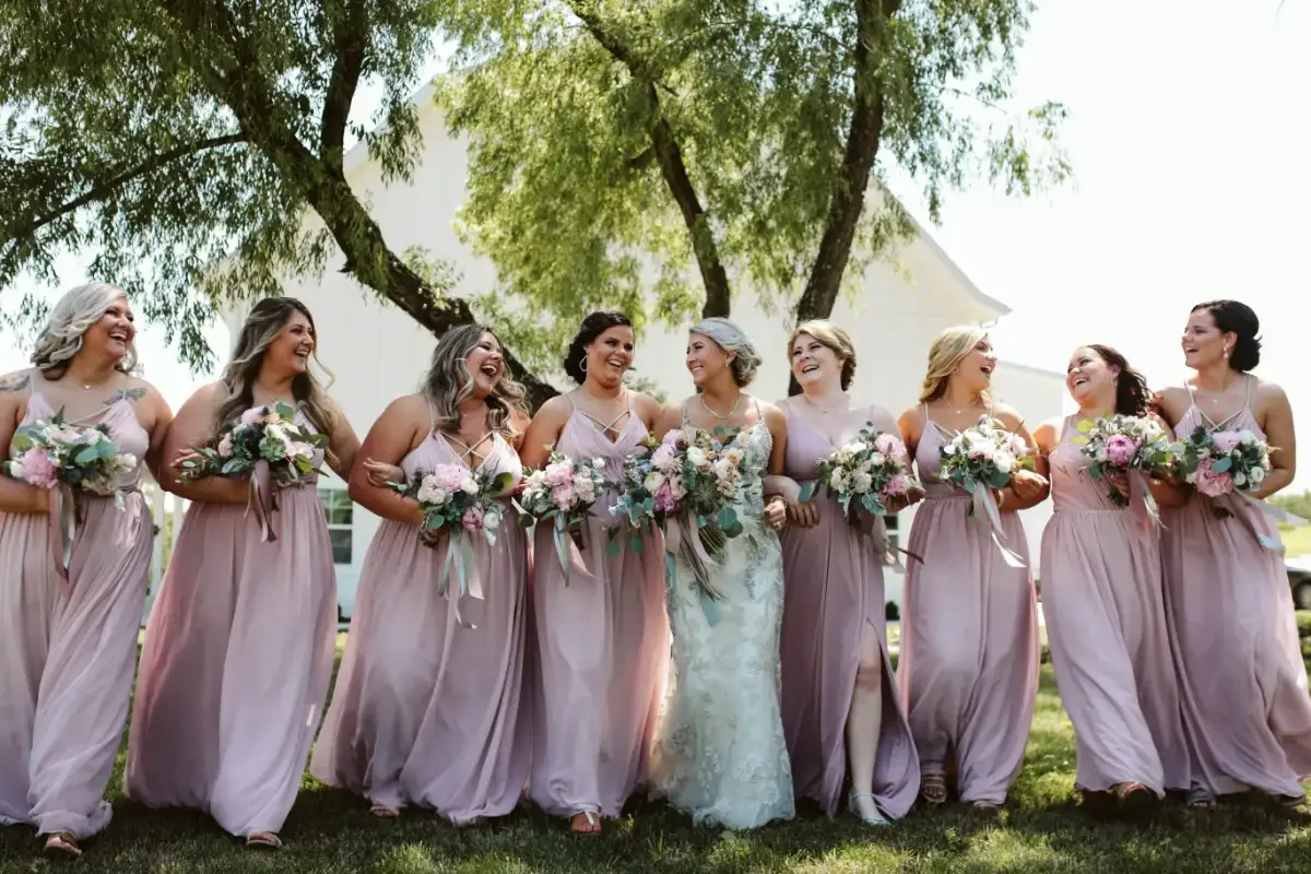 bride-and-bridesmaids-candid-group-photo-sycamore-tree-wedding.webp