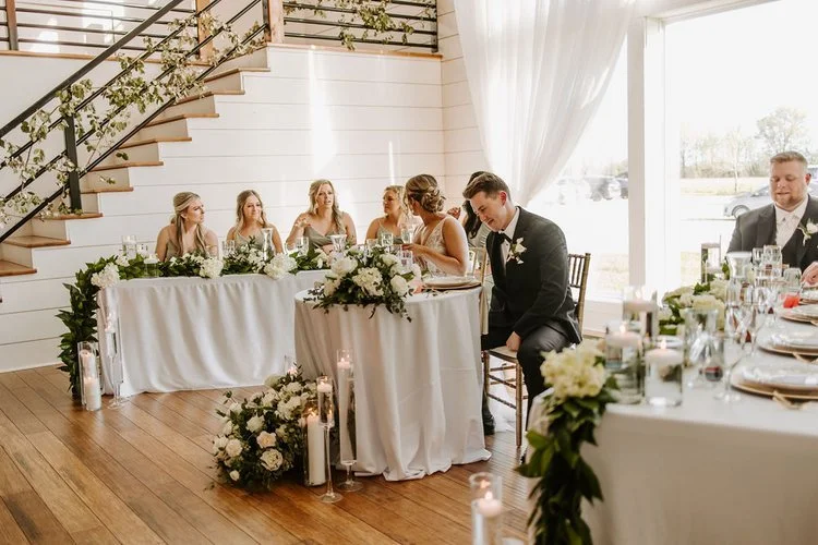 elegant-white-and-green-head-table-florals-with-candles-emerson-fields-floral-stories.jpeg