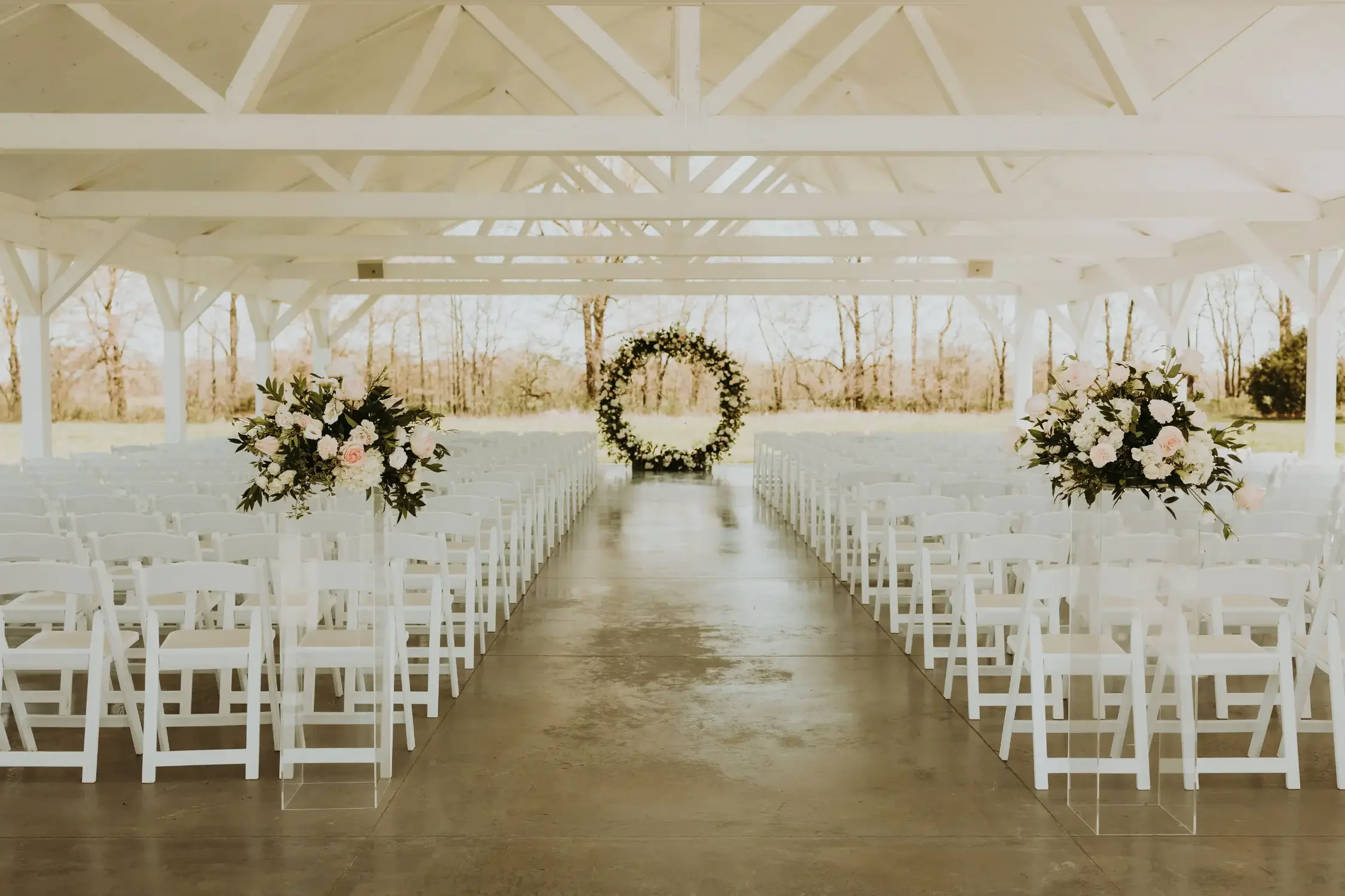 romantic-pavilion-ceremony-setup-white-chairs-emerson-fields-floral-stories.webp