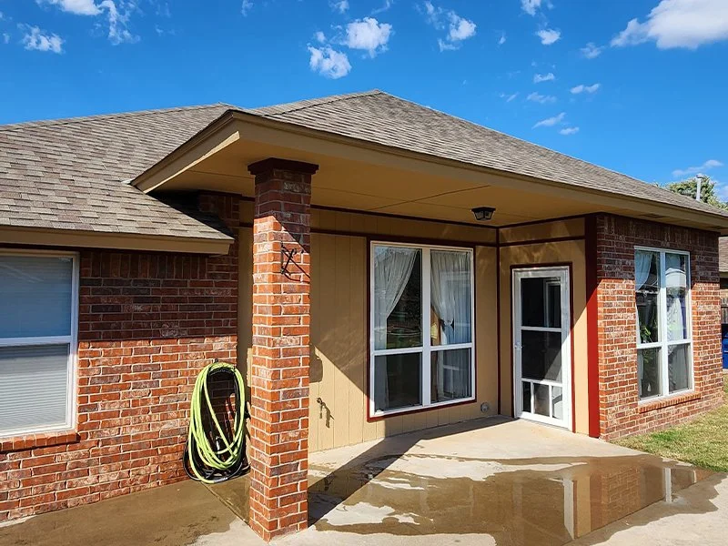 Before and after exterior home improvement project featuring brick wall and patio restoration