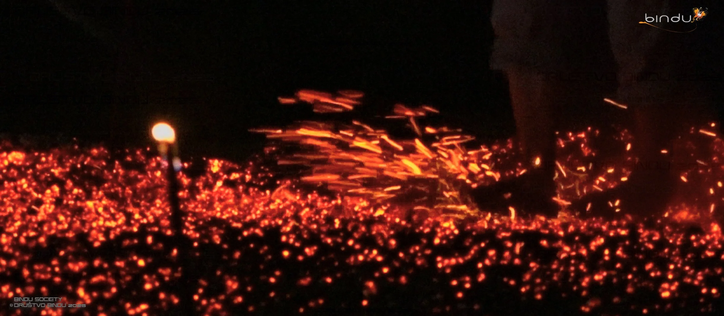 Lava flowing and glowing hot at night, with bright orange and red colors, some sparks and glowing embers.