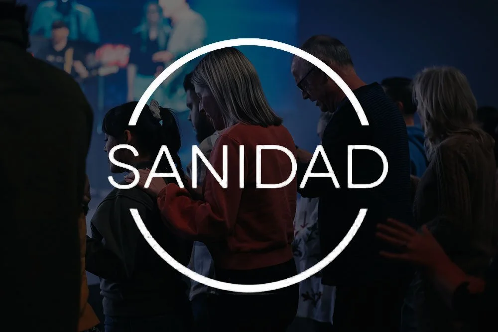 Group of people praying with hands folded, with the word 'SANIDAD' in the center.