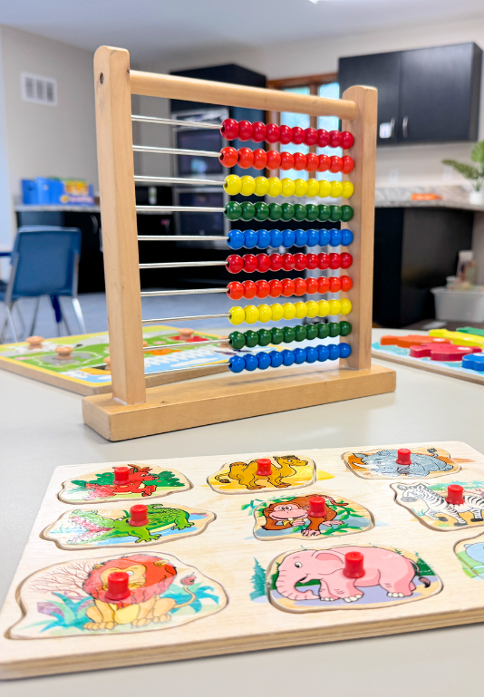 Colorful abacus and animal puzzle toys at Kid Star Daycare Center classroom in Paw Paw, Michigan